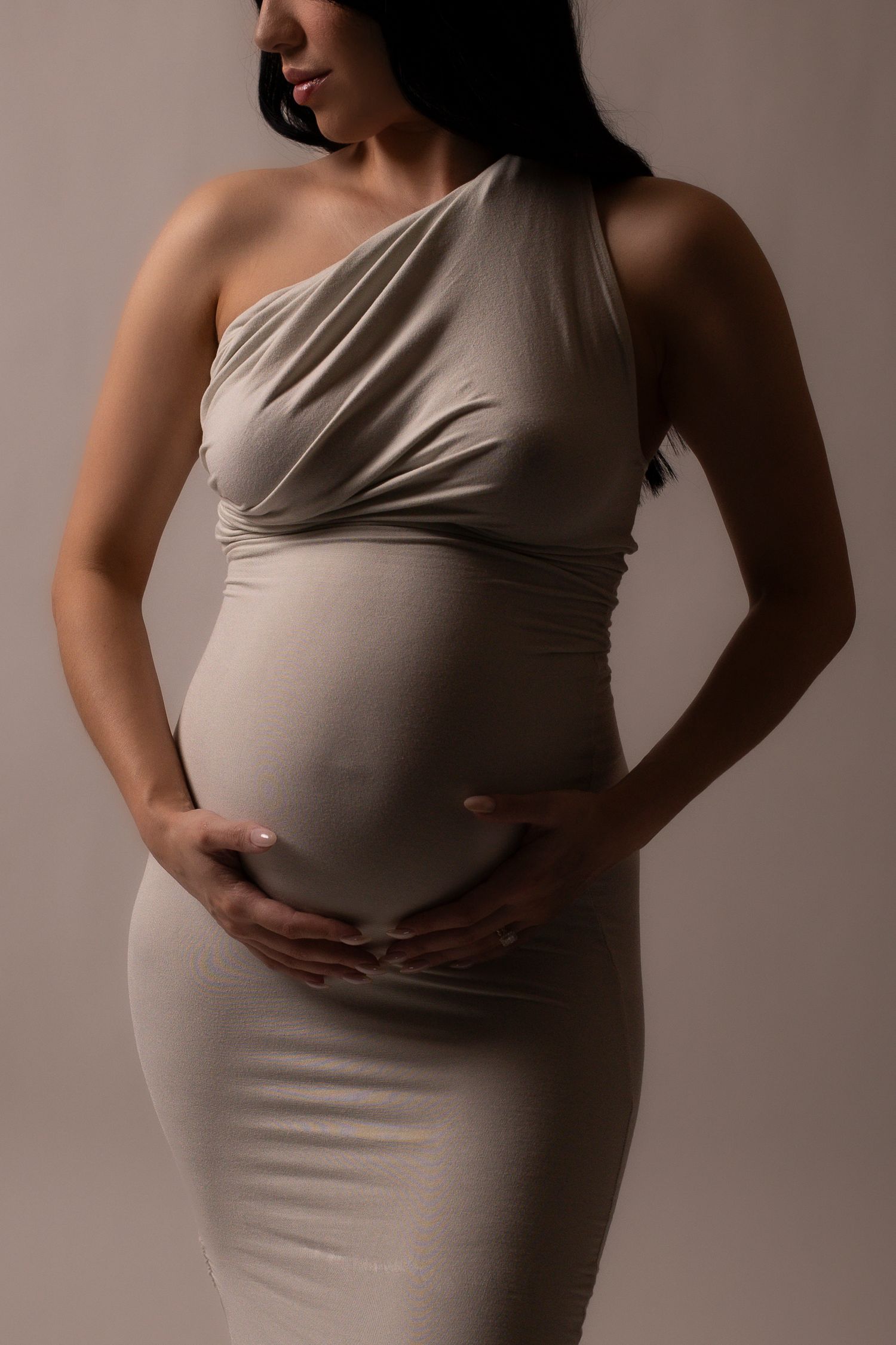 Maternity progression photos showing growing baby bump in neutral colored fitted dress.
