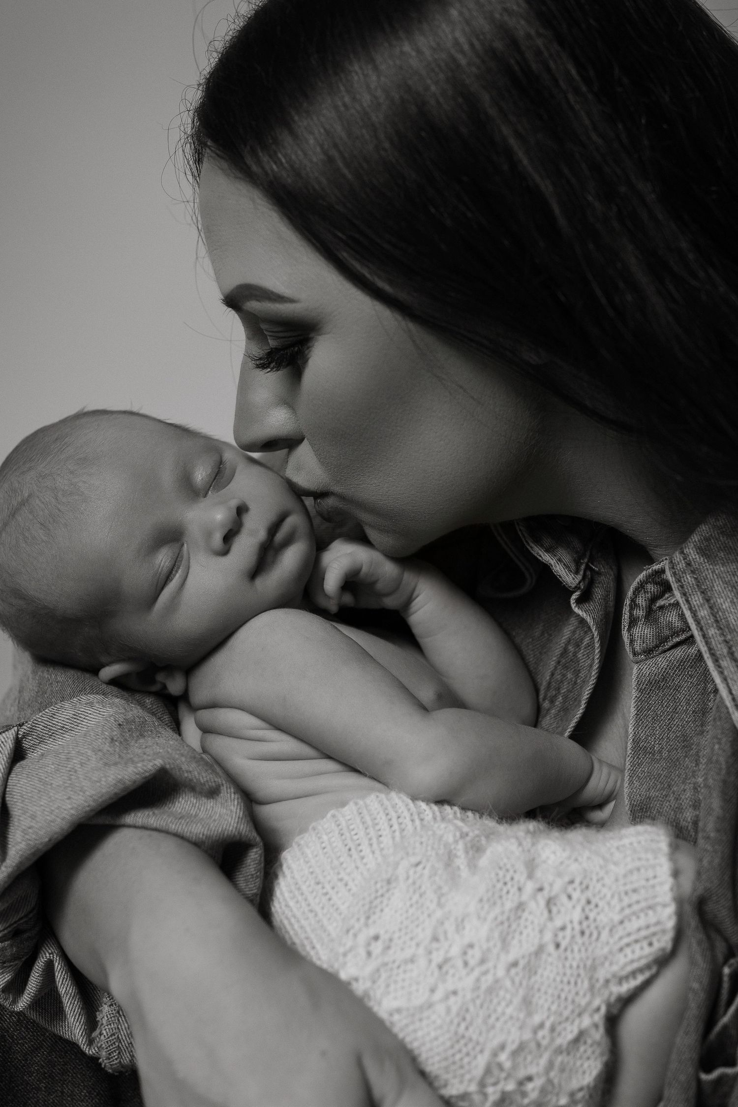 Series of intimate black and white photographs showing tender maternal moments with a baby.