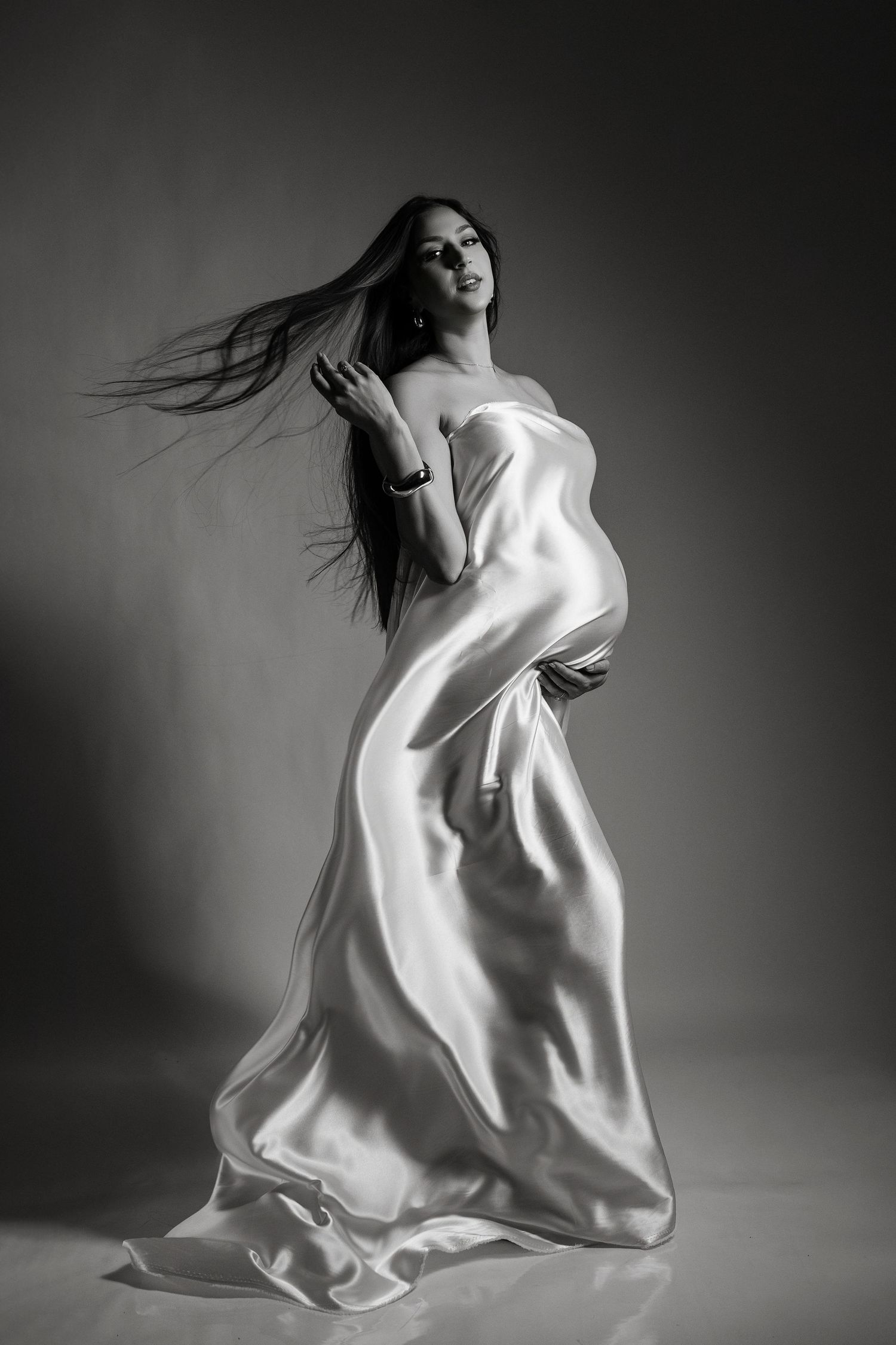 Artistic black and white photo series showing dynamic movement with flowing white fabric against dark background.