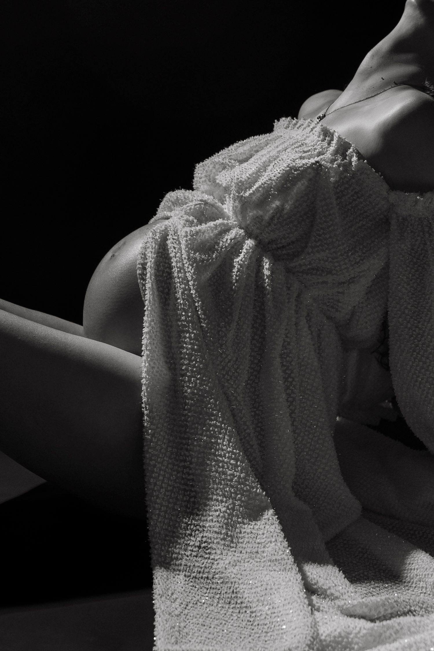 Fine art boudoir photography series capturing elegant white lace fabric draping against a dark background.