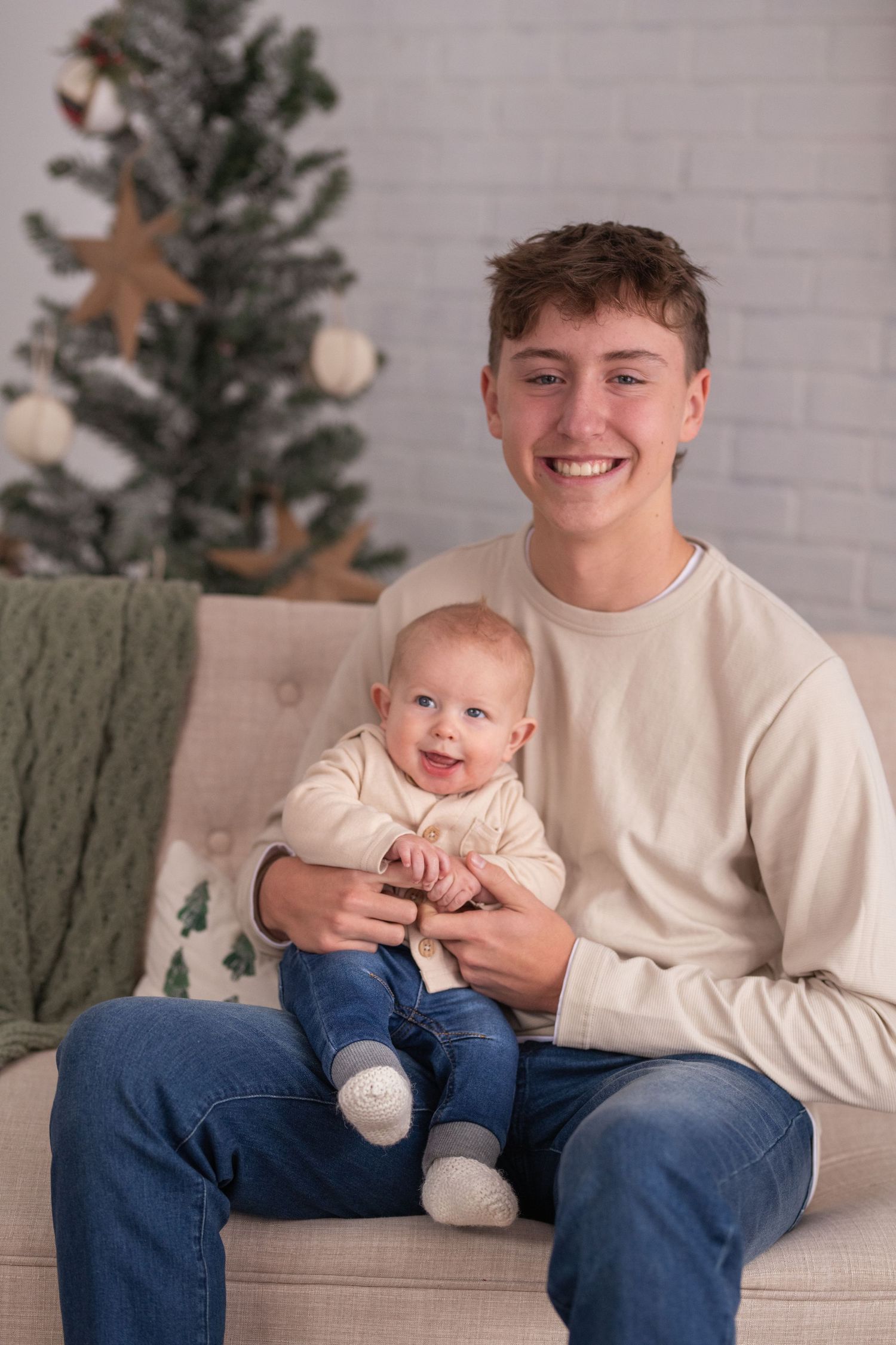 A heartwarming series of candid couch moments showing interaction between a teen in cream sweater and baby in white outfit.