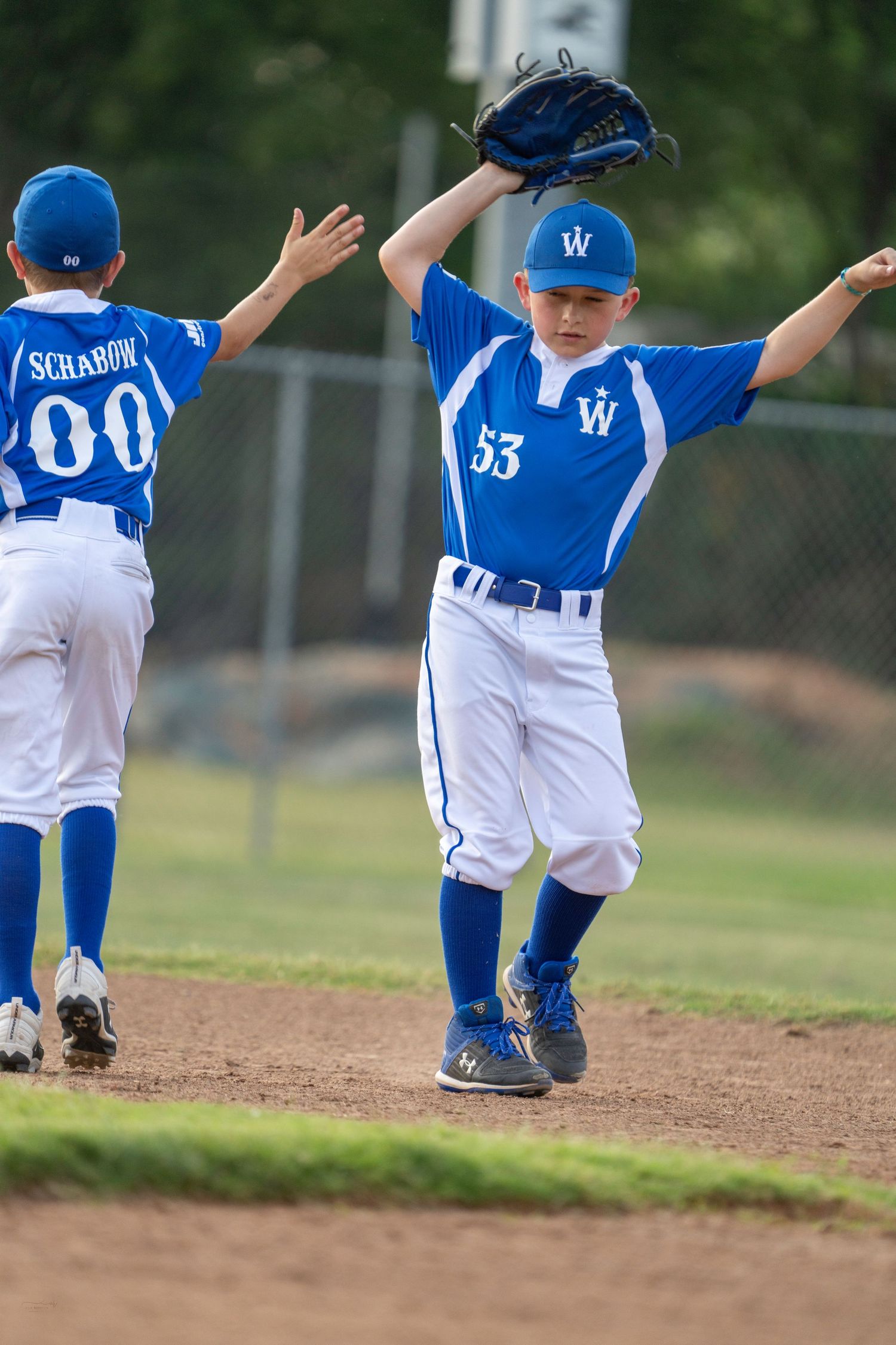 A sequence of photos showing a baseball player sliding across the base during a baseball game in blue and white uniform.