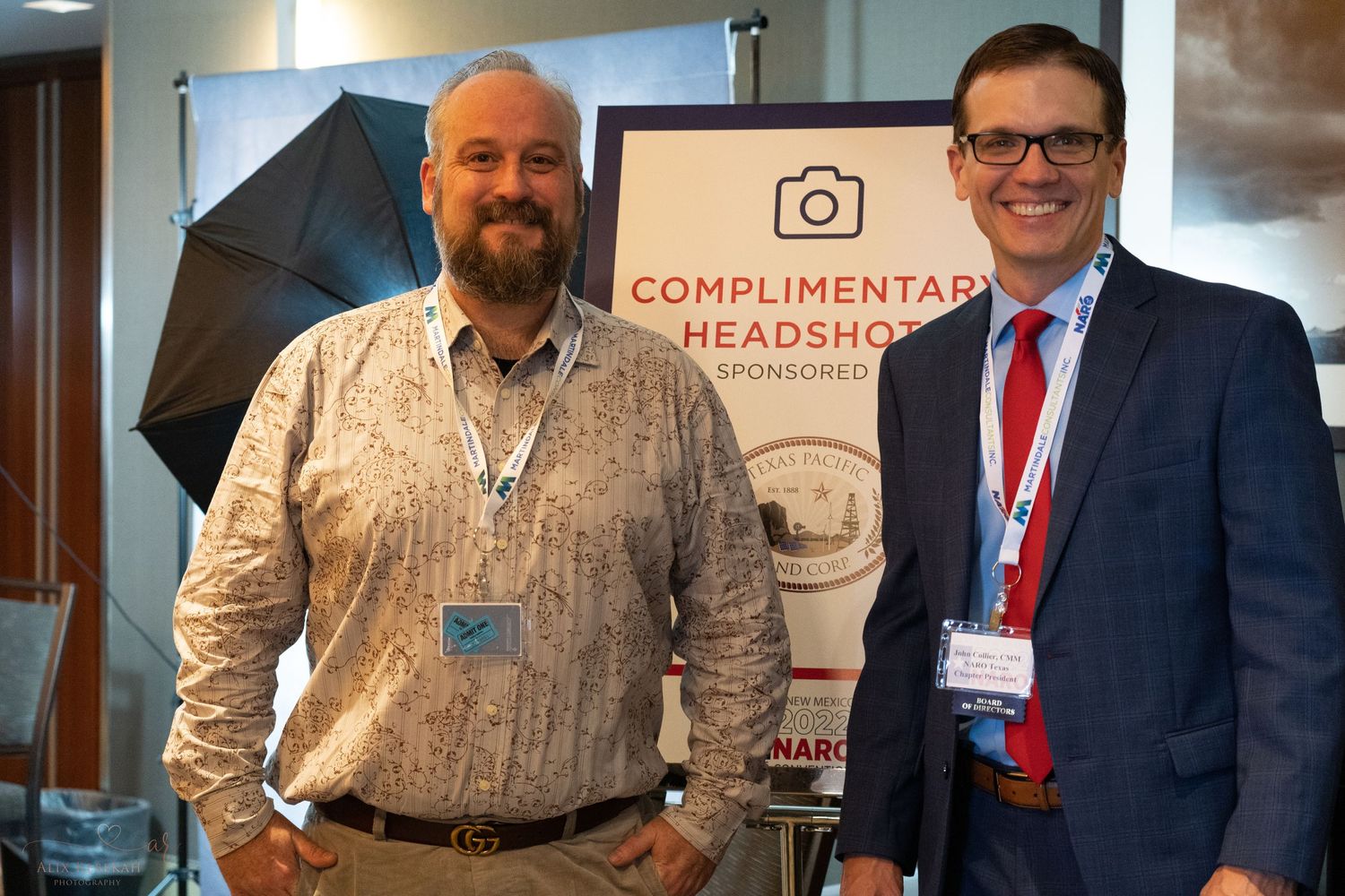 Two conference attendees posing by complimentary headshot photography station.