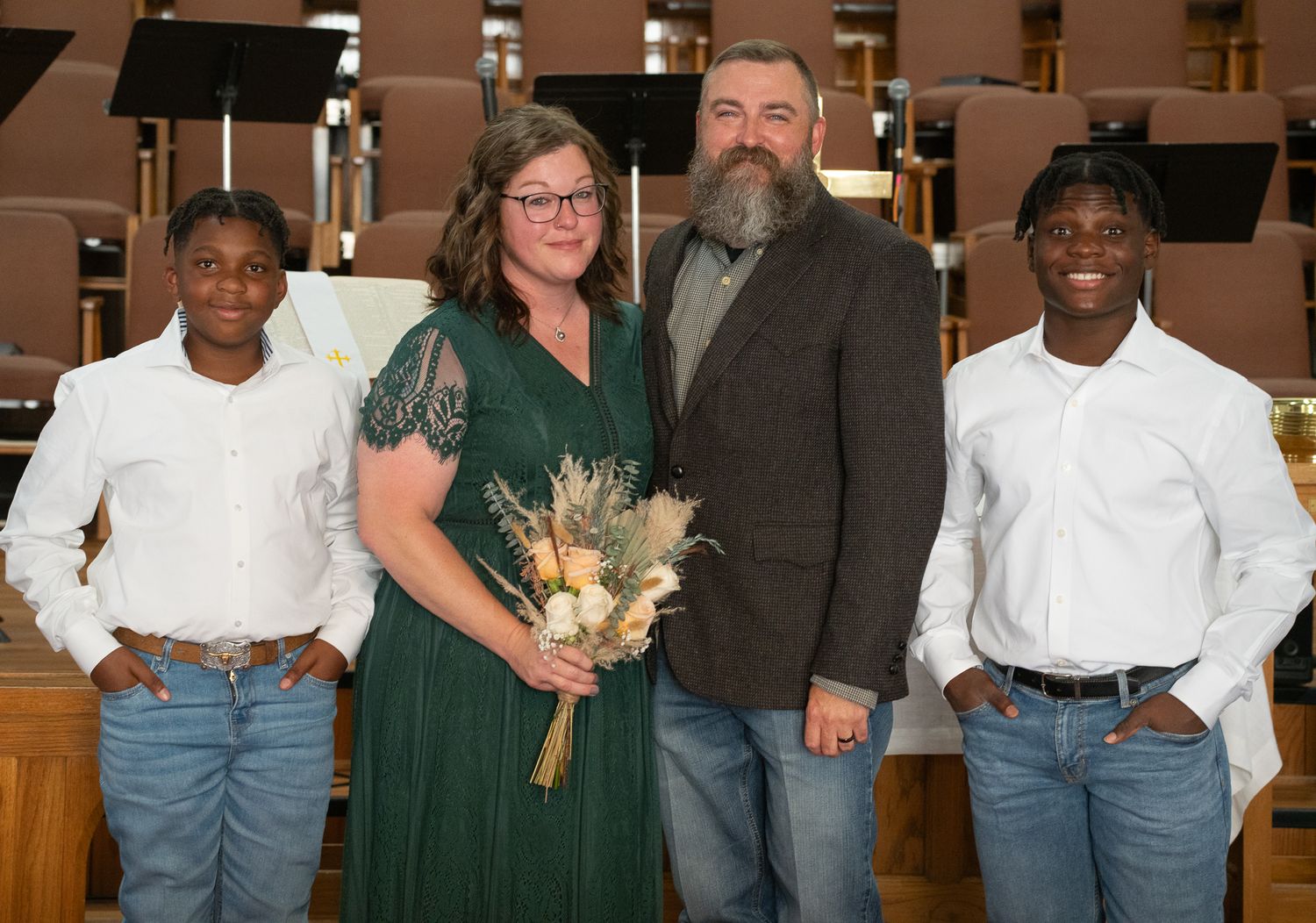 Group portrait in church with music stands and formal attire.