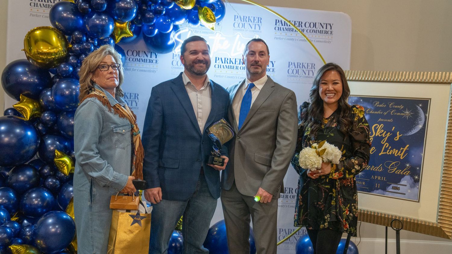 Group photo of award recipients at a chamber of commerce event with balloon decorations.