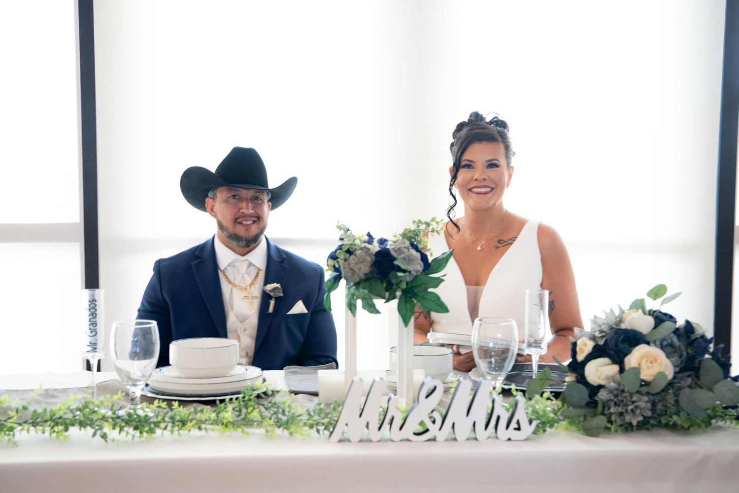 Wedding reception table setting with elegant decor and floral arrangements.