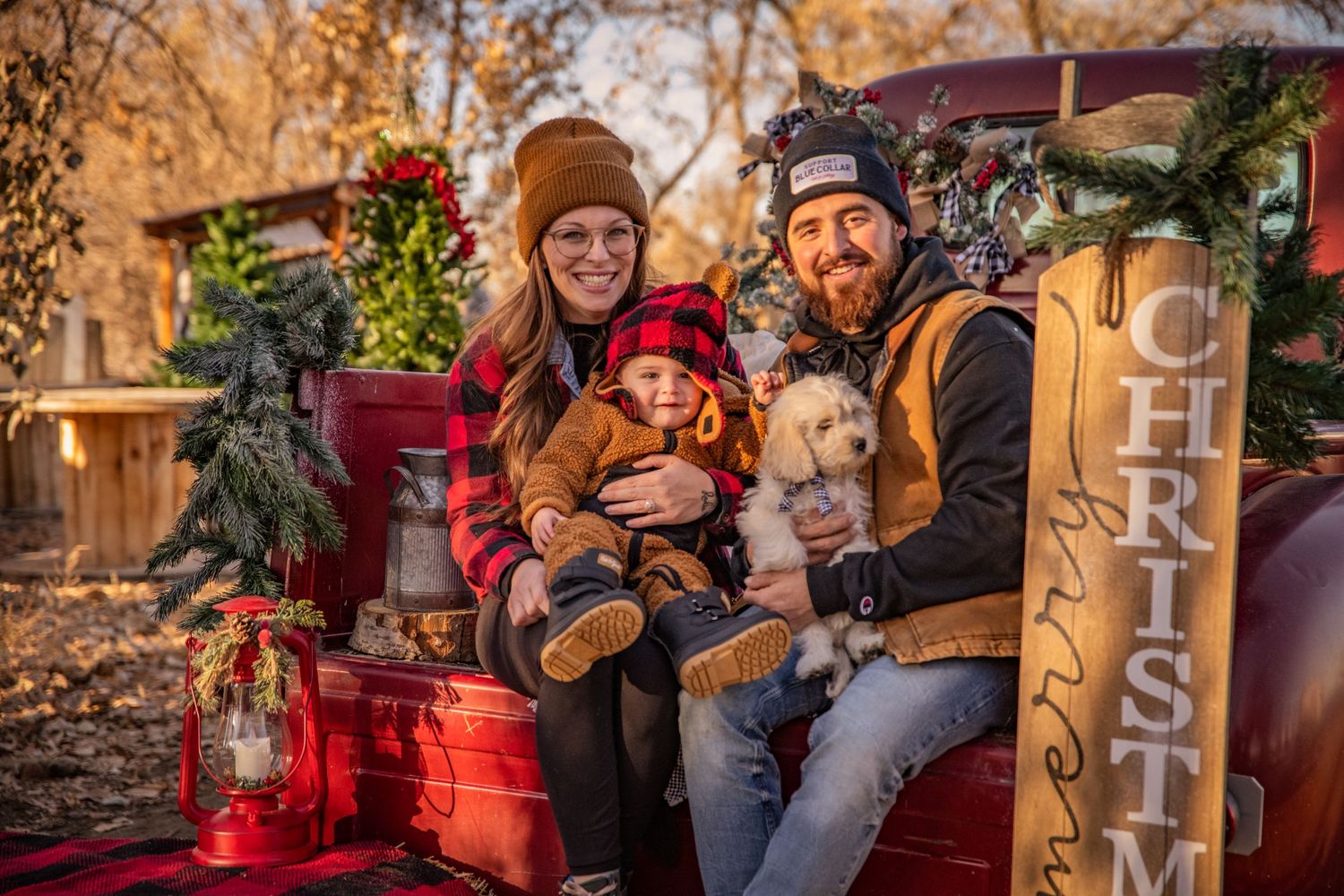 Holiday family portrait with vintage decorations and red truck featuring festive Christmas scene.