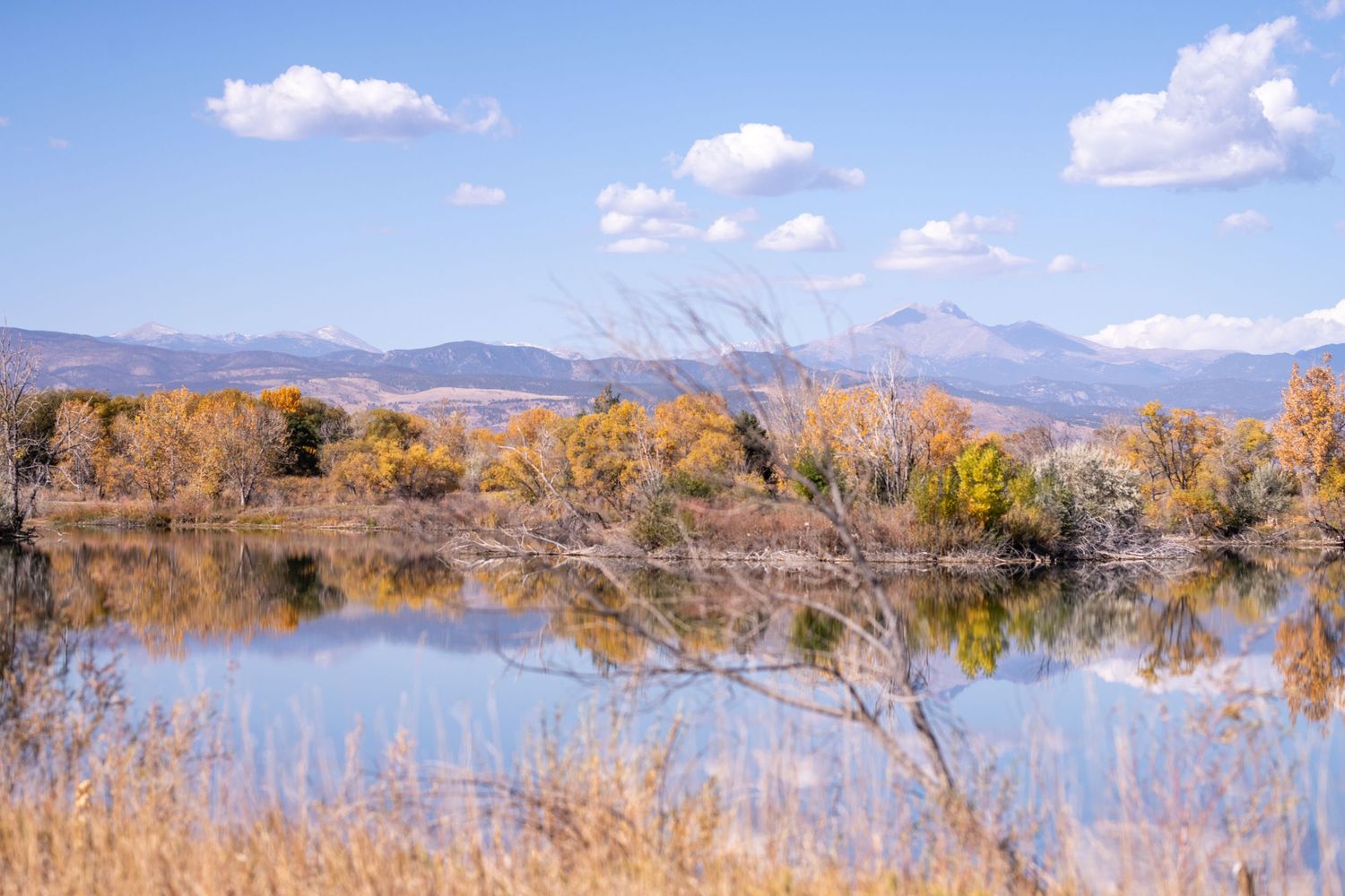 Scenic mountain lake landscape with fall colors and blue sky reflections.