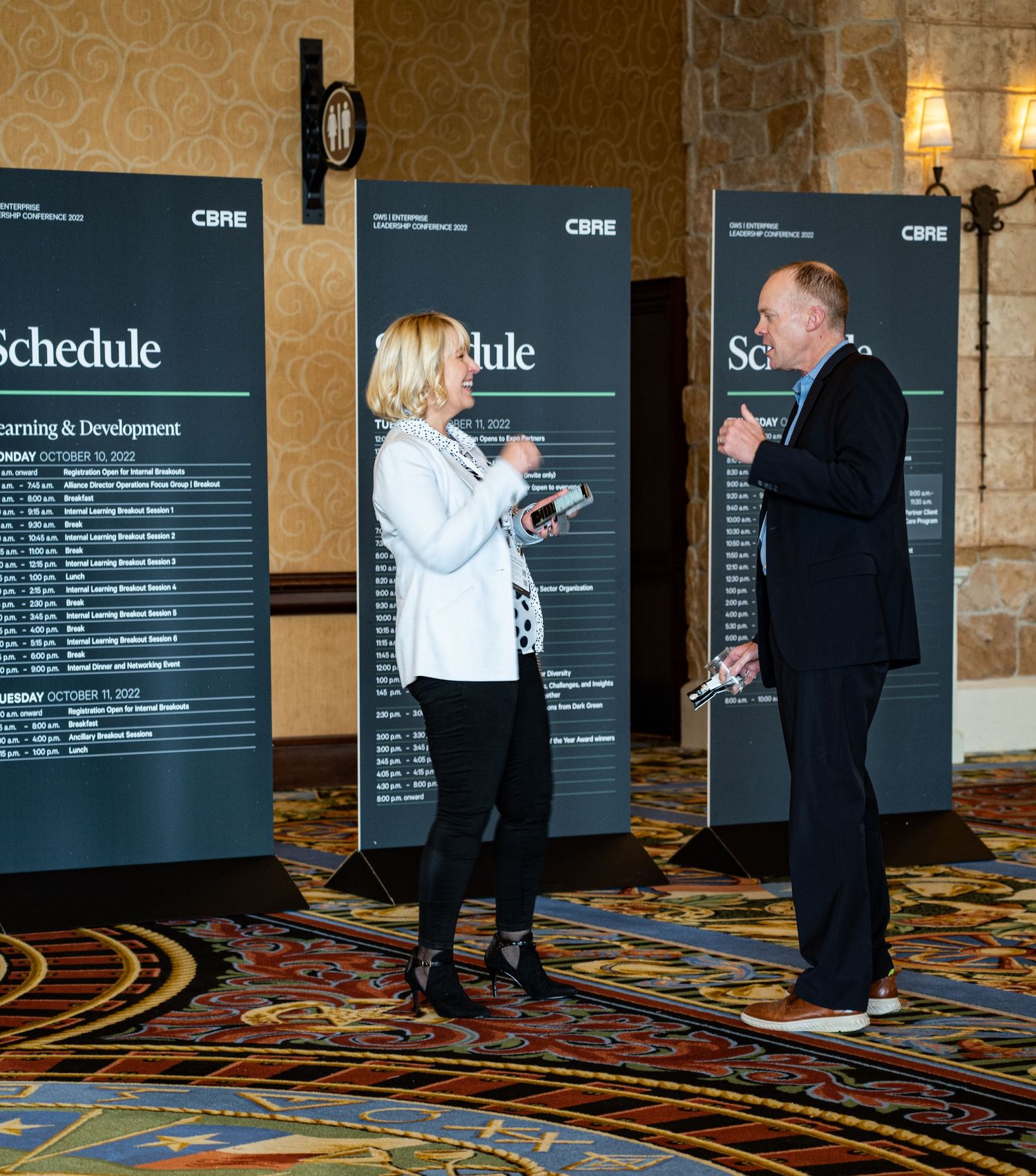 Conference attendees reviewing a schedule board at a business event.