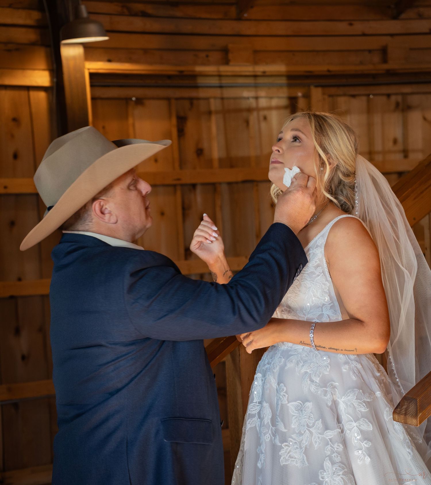A heartwarming moment between two people sharing cake at a rustic barn wedding reception.