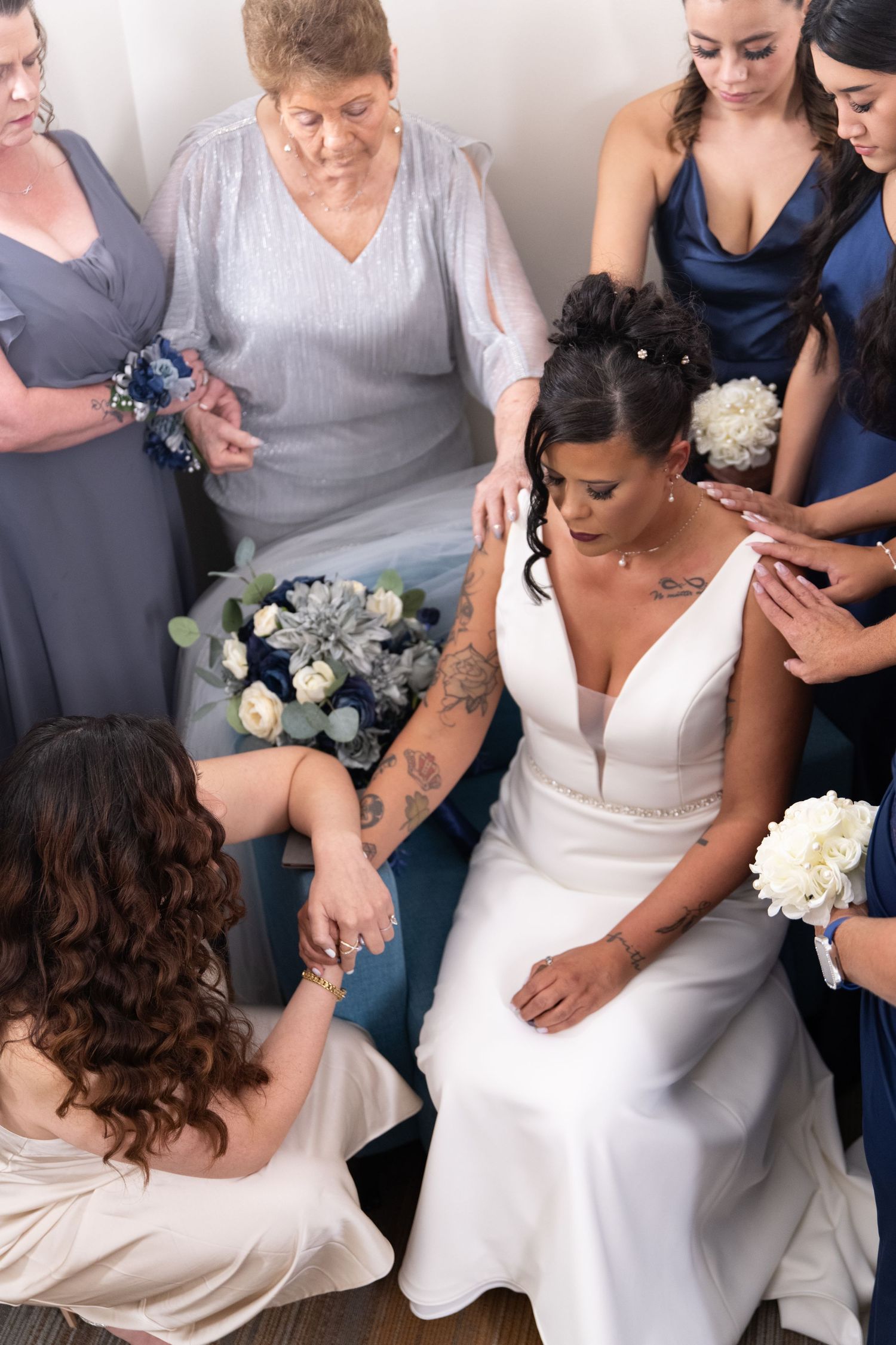Group gathered around in formal attire with blue and white floral arrangements.