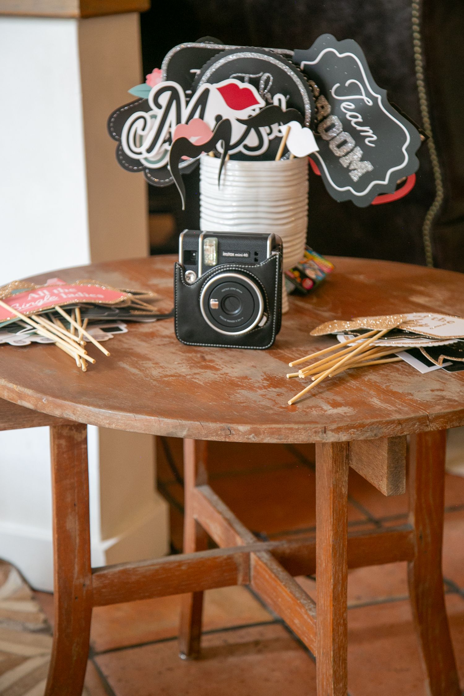 A vintage camera and party props displayed on a rustic wooden table.