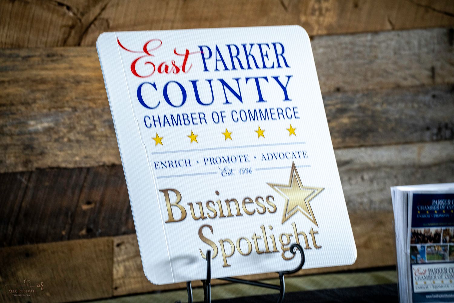 Parker County Chamber of Commerce Business Spotlight sign mounted on rustic wooden wall.