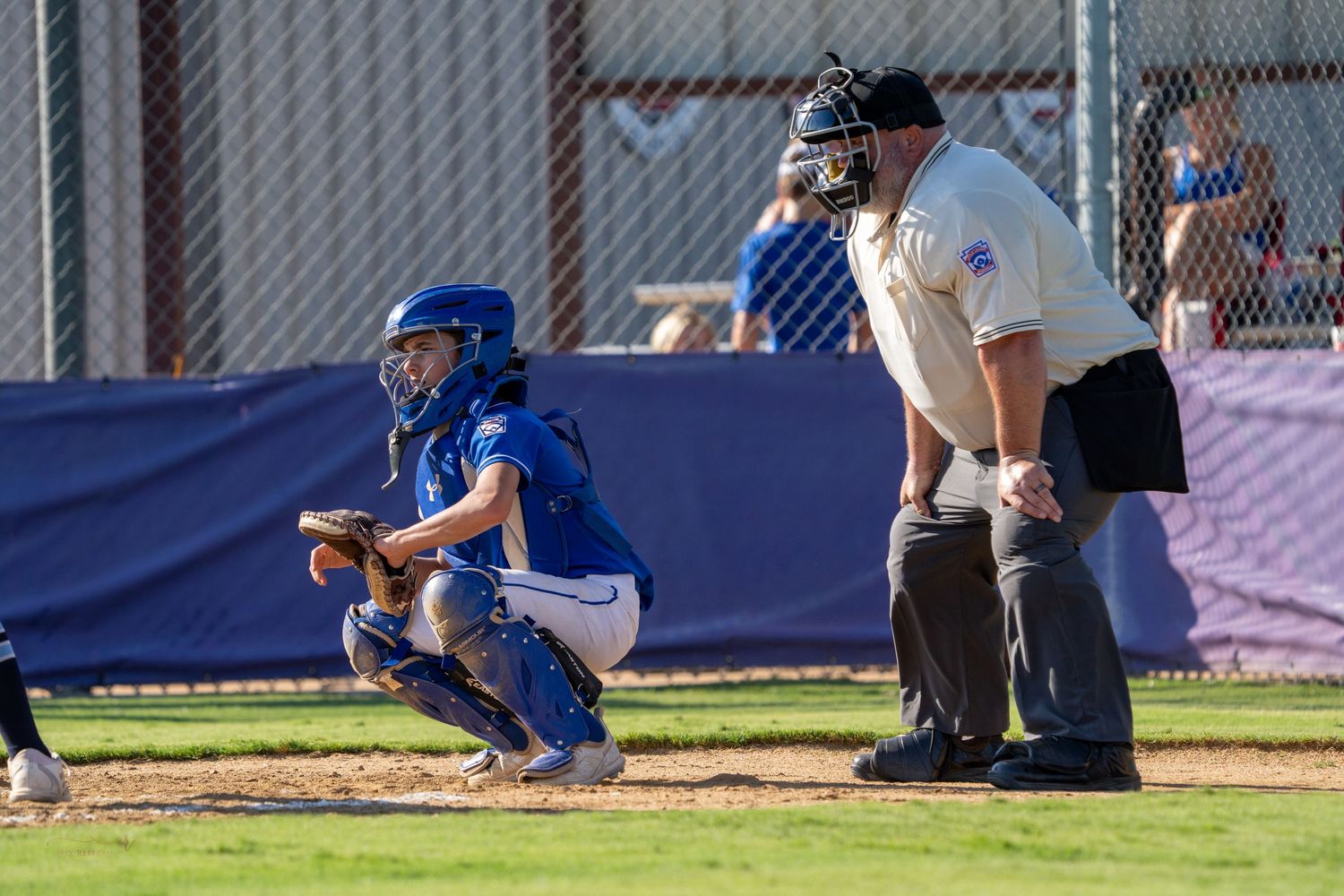 Baseball player in blue uniform makes a play during infield ground ball in competitive game action.