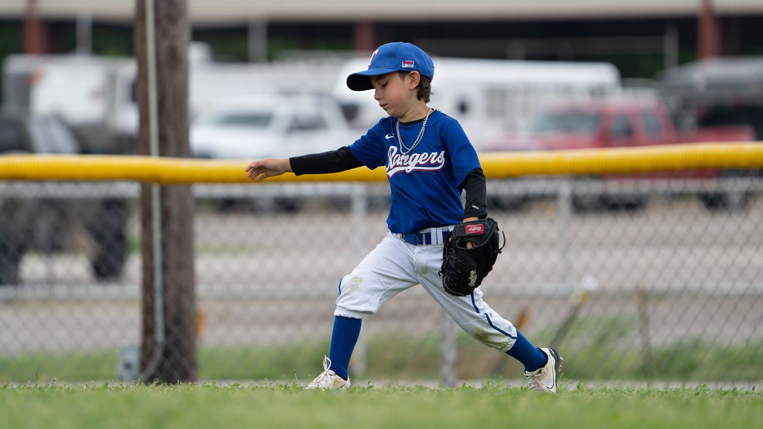 A baseball player in a blue uniform executes a sliding play during a game.