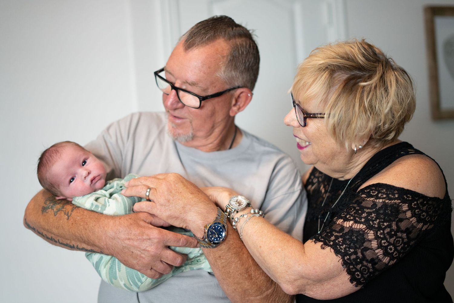 A tender moment between adults and an infant in a cozy indoor setting.