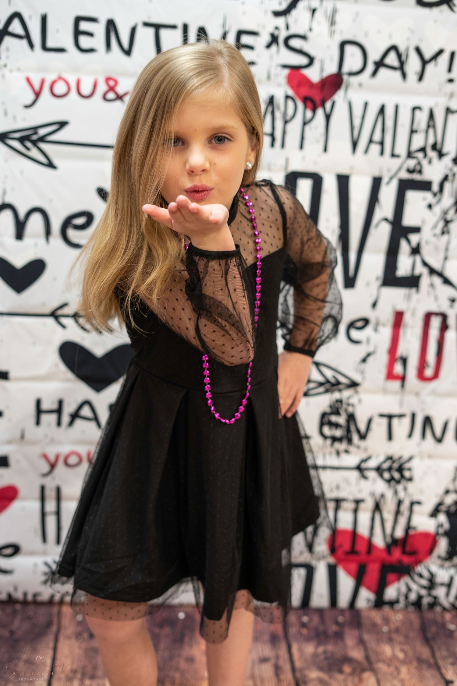 Valentine's themed photo setup with black dress and graffiti backdrop.