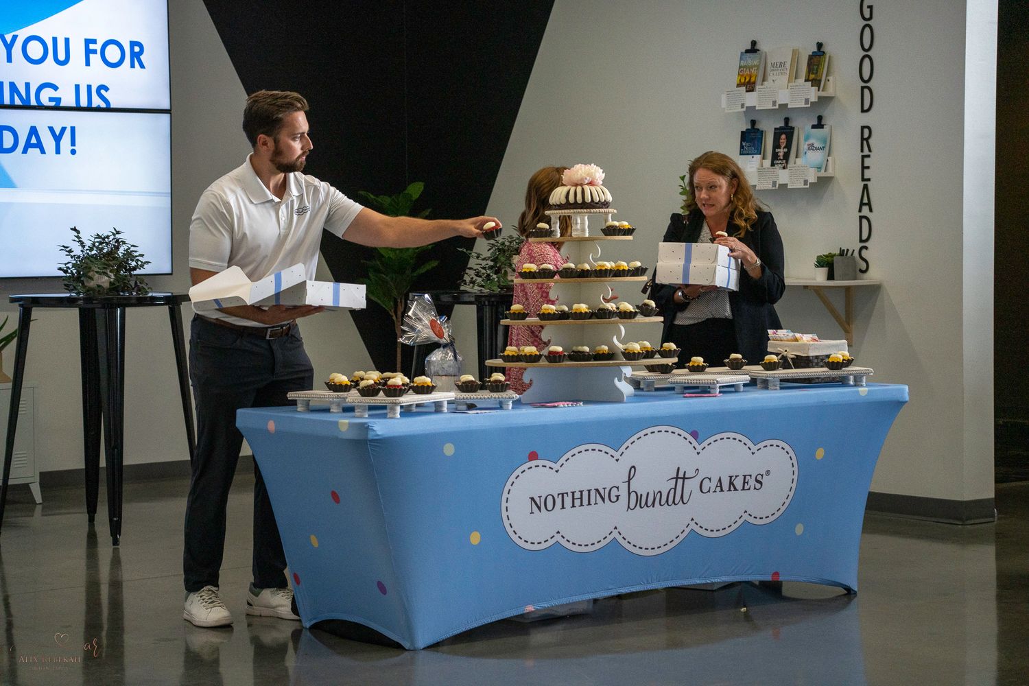 Vendor booth displaying Nothing Bundt Cakes products with staff members at business event.