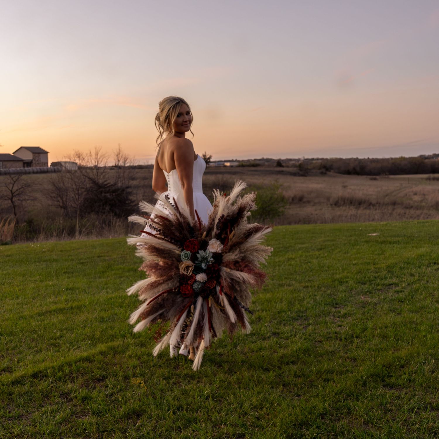 A scenic bridal portrait series at sunset showing a figure in a dress walking through a grassy meadow.