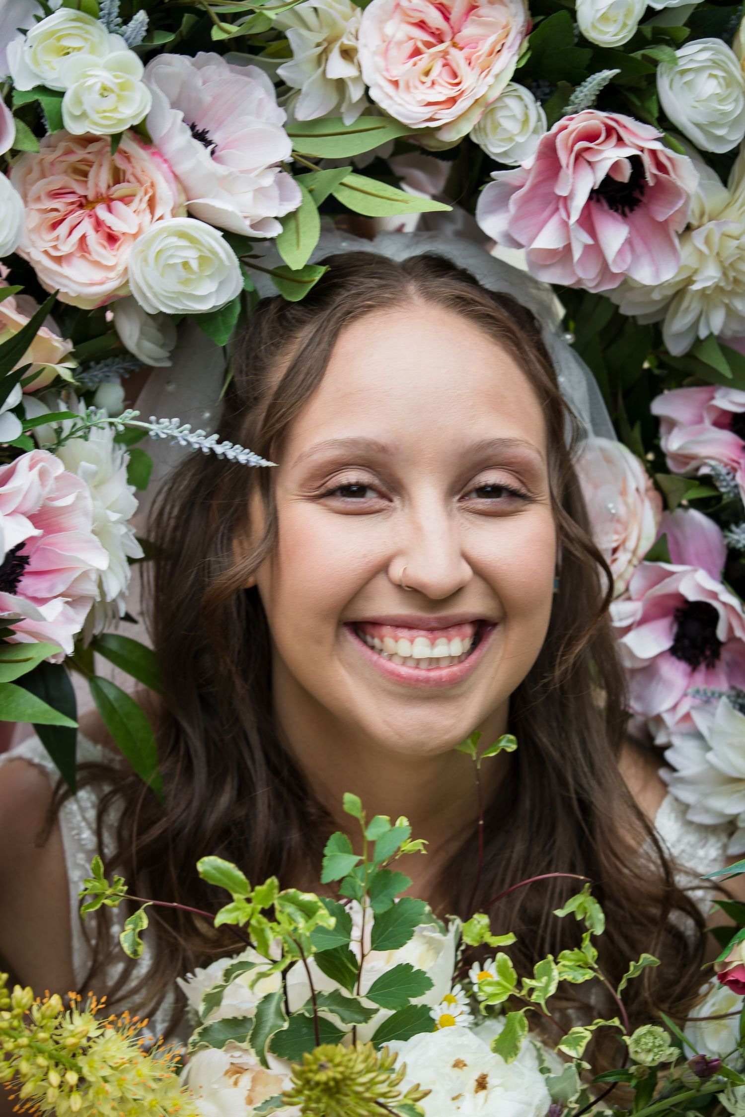 Floral crown frames delicate pink and white roses with greenery.