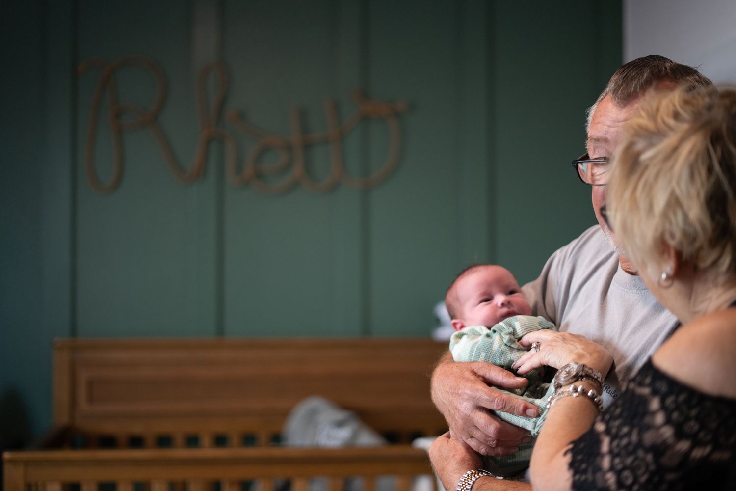 A quiet nurturing moment with a newborn baby in a softly lit room.