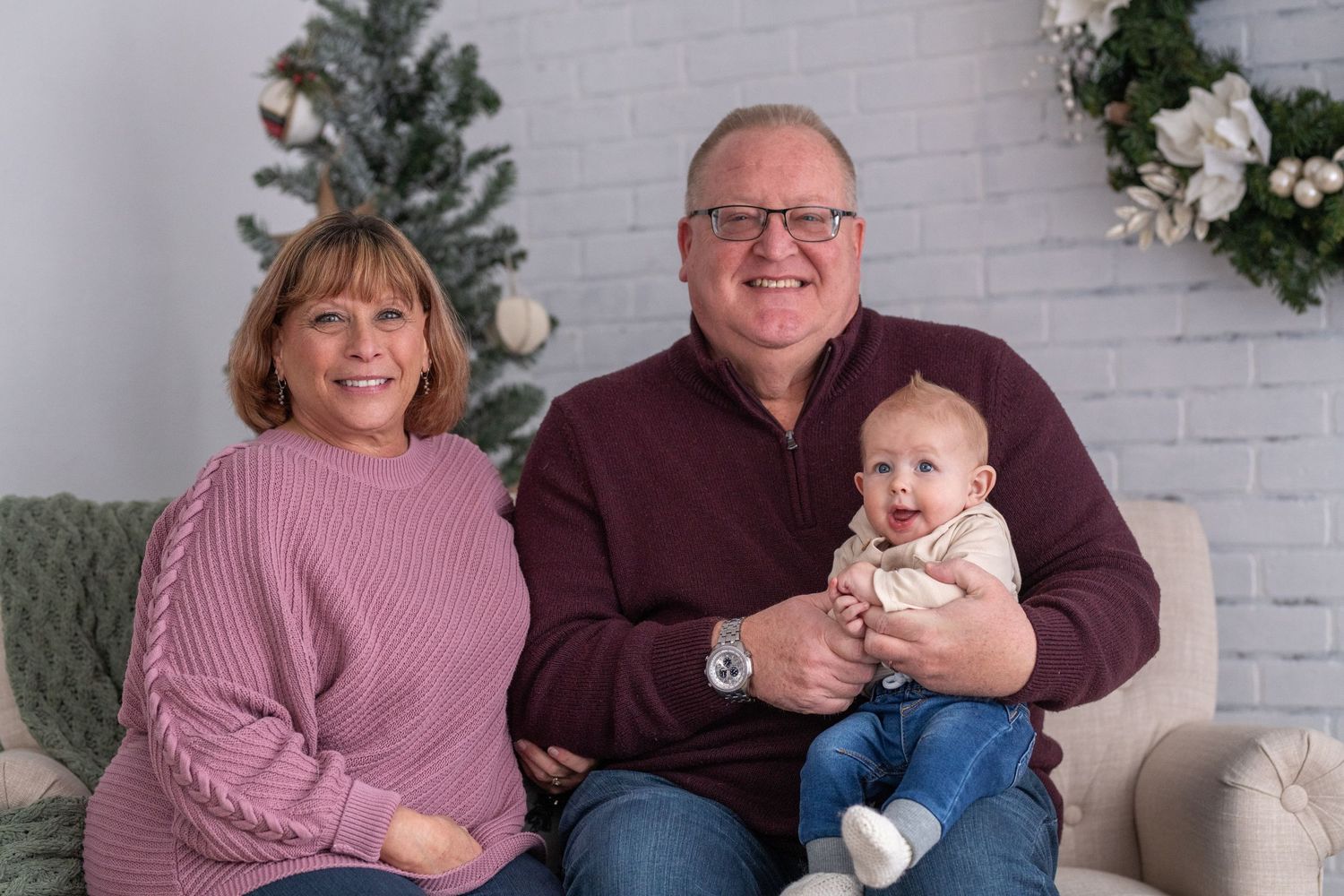 A series of family photos in coordinating burgundy and pink outfits taken against a white brick wall background.