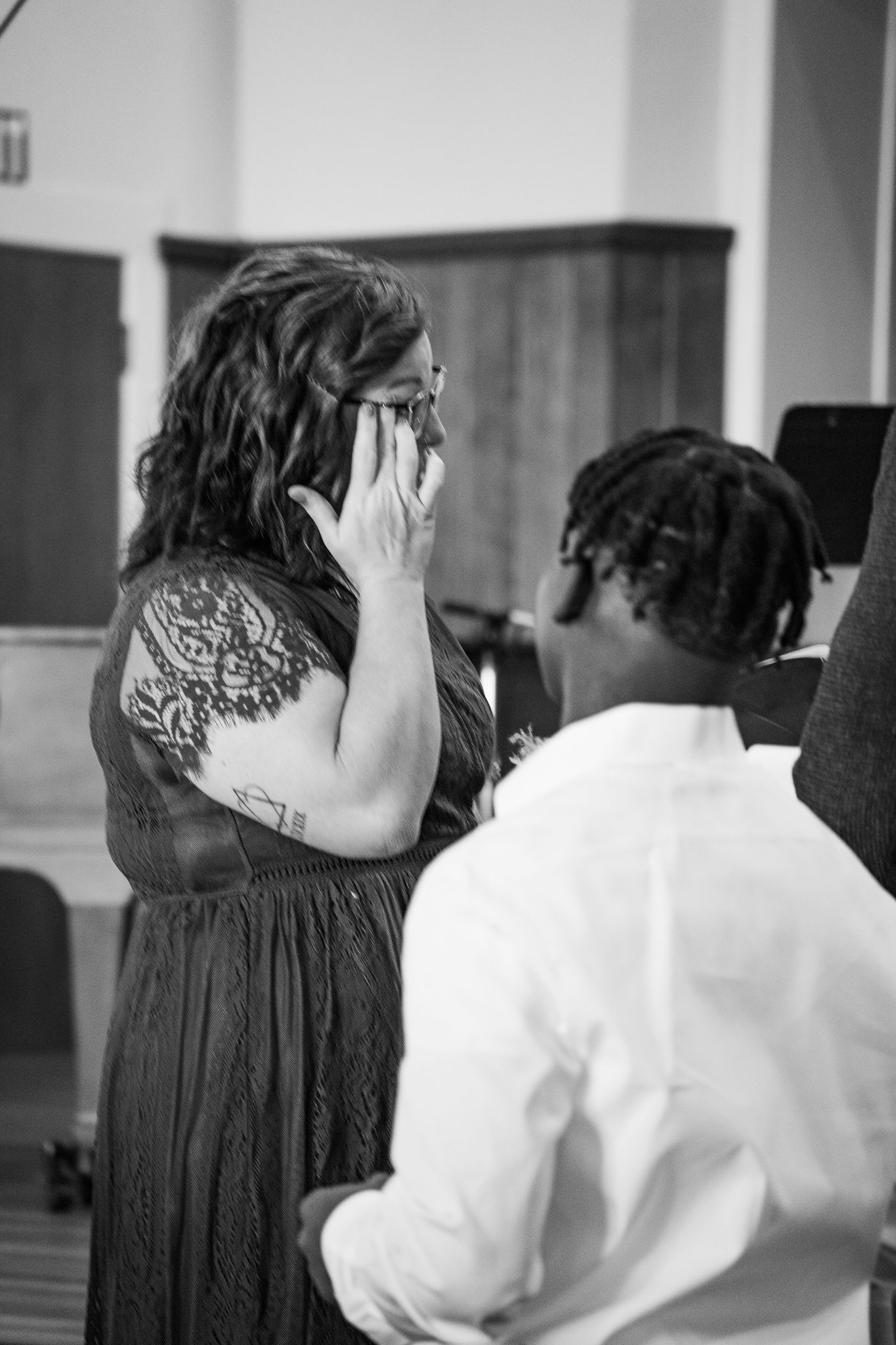 Emotional black and white wedding moment in church setting.