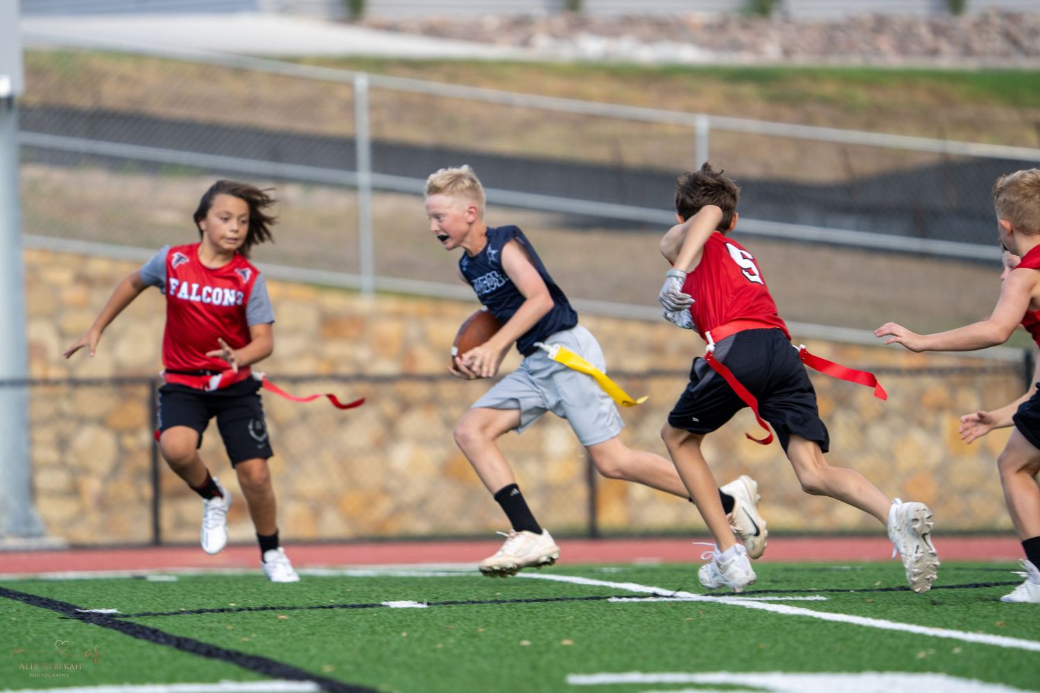 Athletes competing in intense field sport match with players running and dodging.