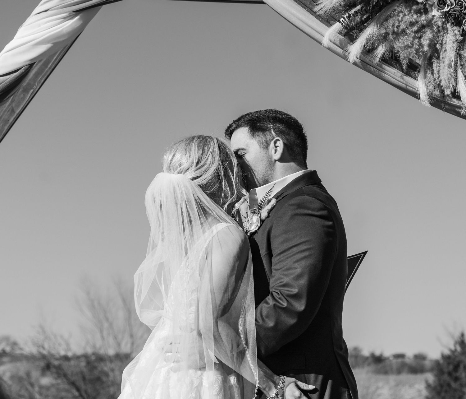 Black and white photo series shows intimate wedding moments between newlyweds standing together outdoors.