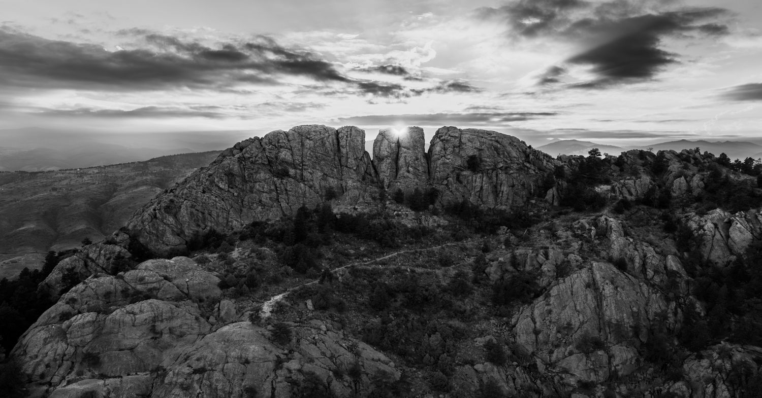Dramatic black and white panorama of rugged mountain peaks against a cloudy sky. Horsetooth Mountain