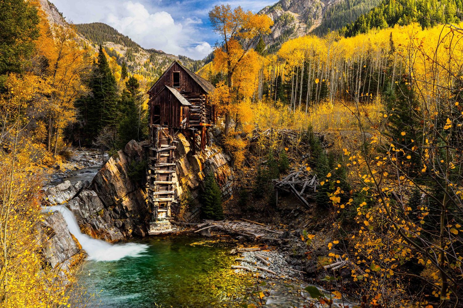 Mountain creek flows through golden aspen forest in dramatic autumn landscape. The Crystal Mill