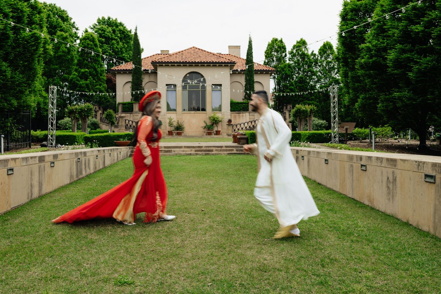 couple running. Running photos. Engagement session in the gardens. Philbrook museum of art, tulsa Oklahoma. Bride and groom. Gardens. field.