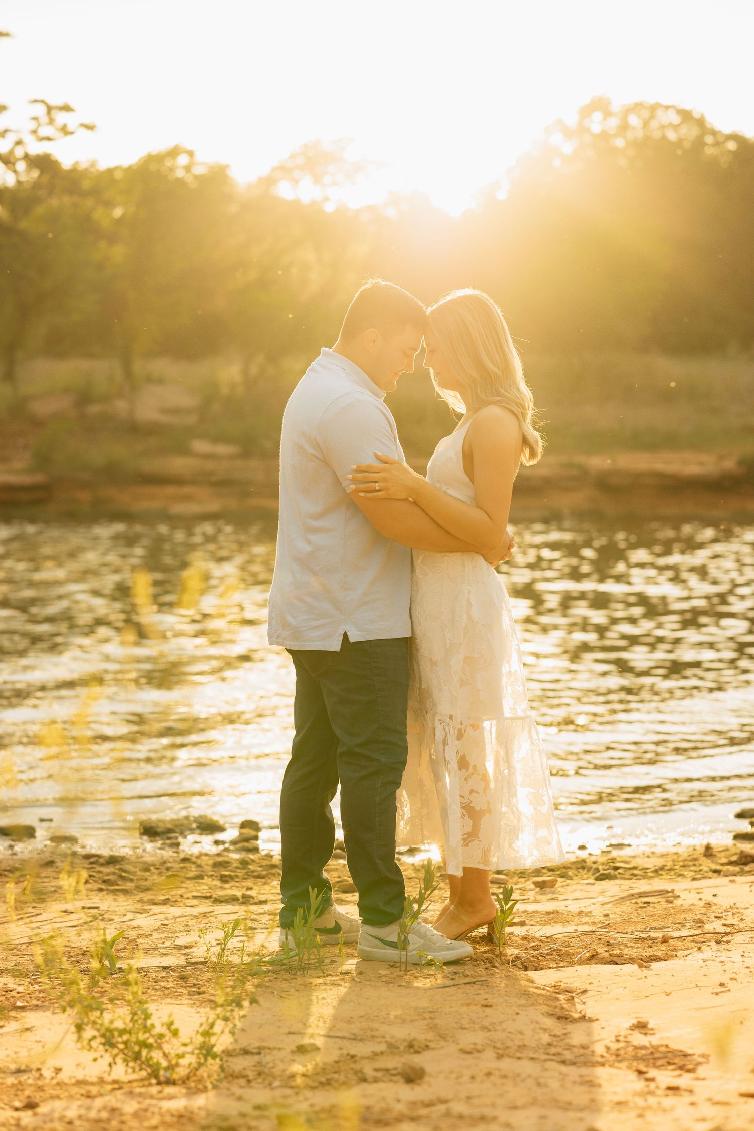 Engagement session by the lake during golden hour. Bride is wearing a white dress. Lake arcadia engagement session.