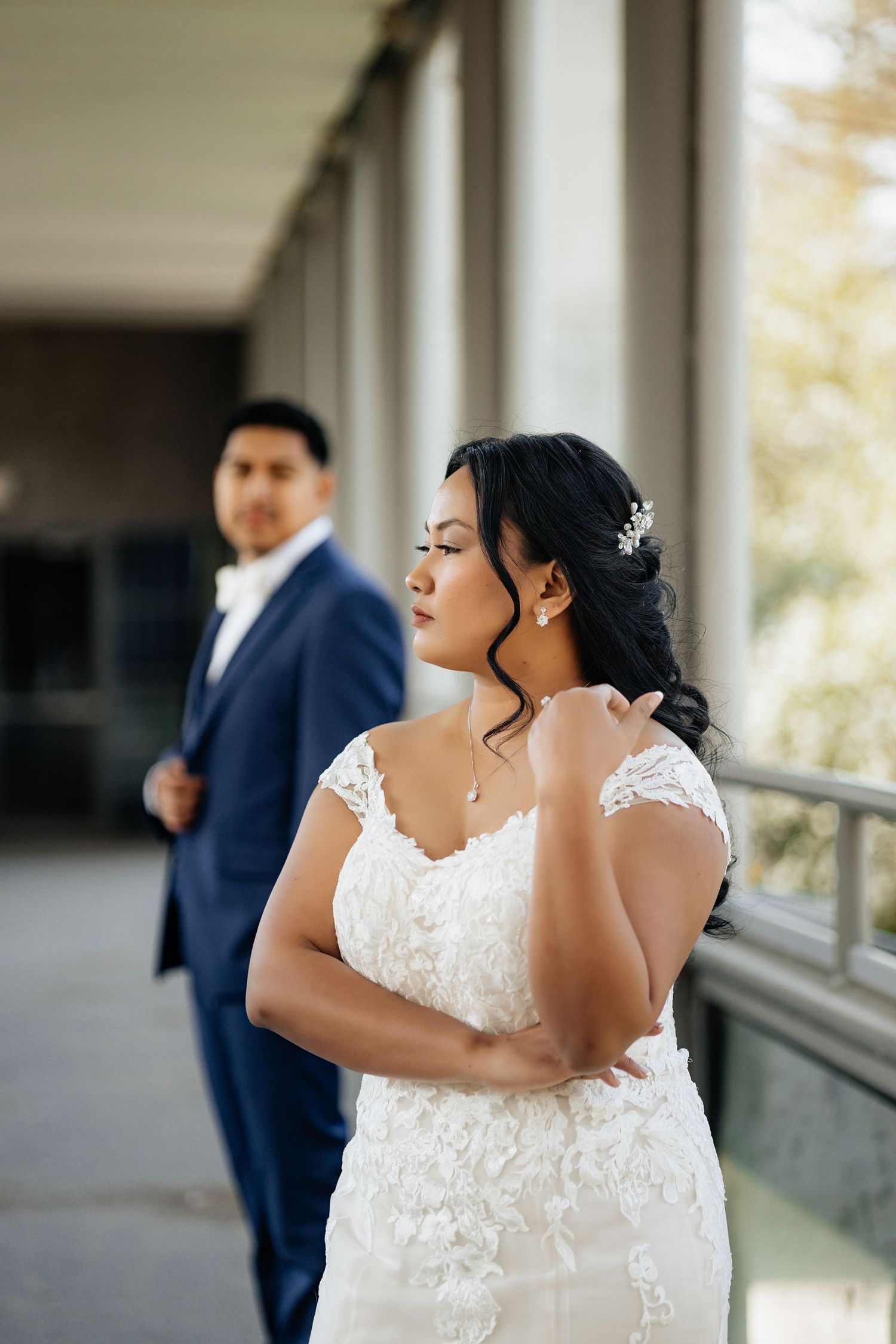 Bride and groom on their wedding day in downtown oklahoma city. Bride is dressed in a white dress. Groom is in a navy suit. Multicultural.