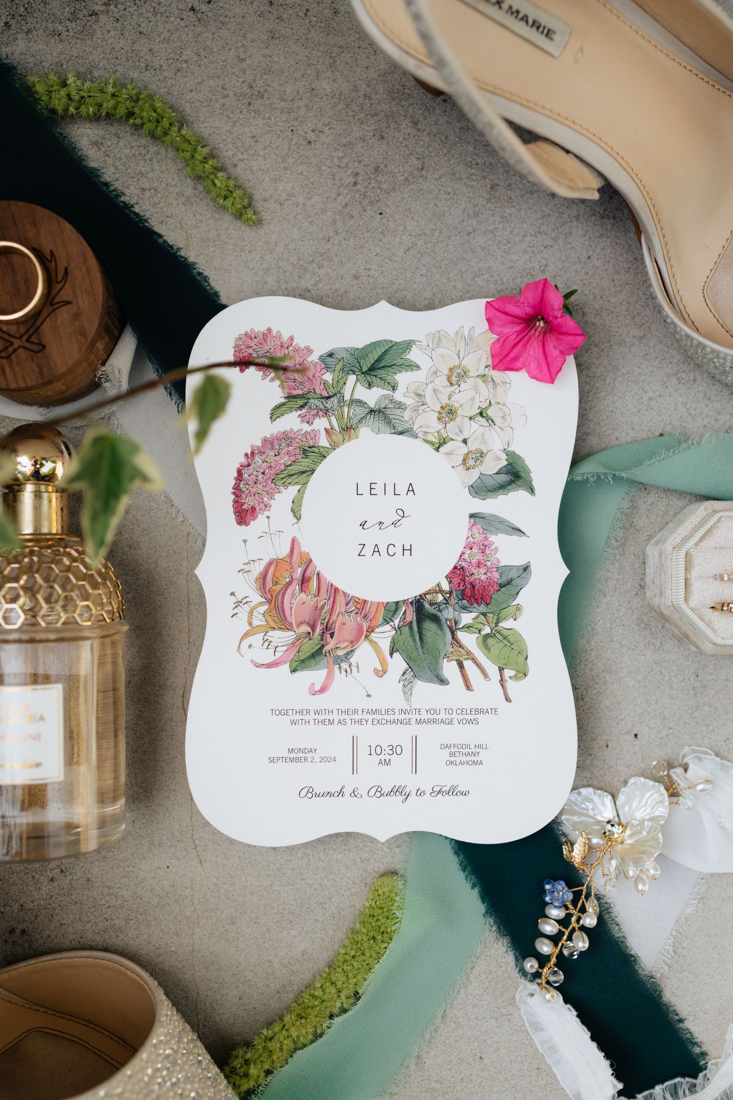Wedding day details with a colorful wedding invitation and other details such as perfume and jewelry.