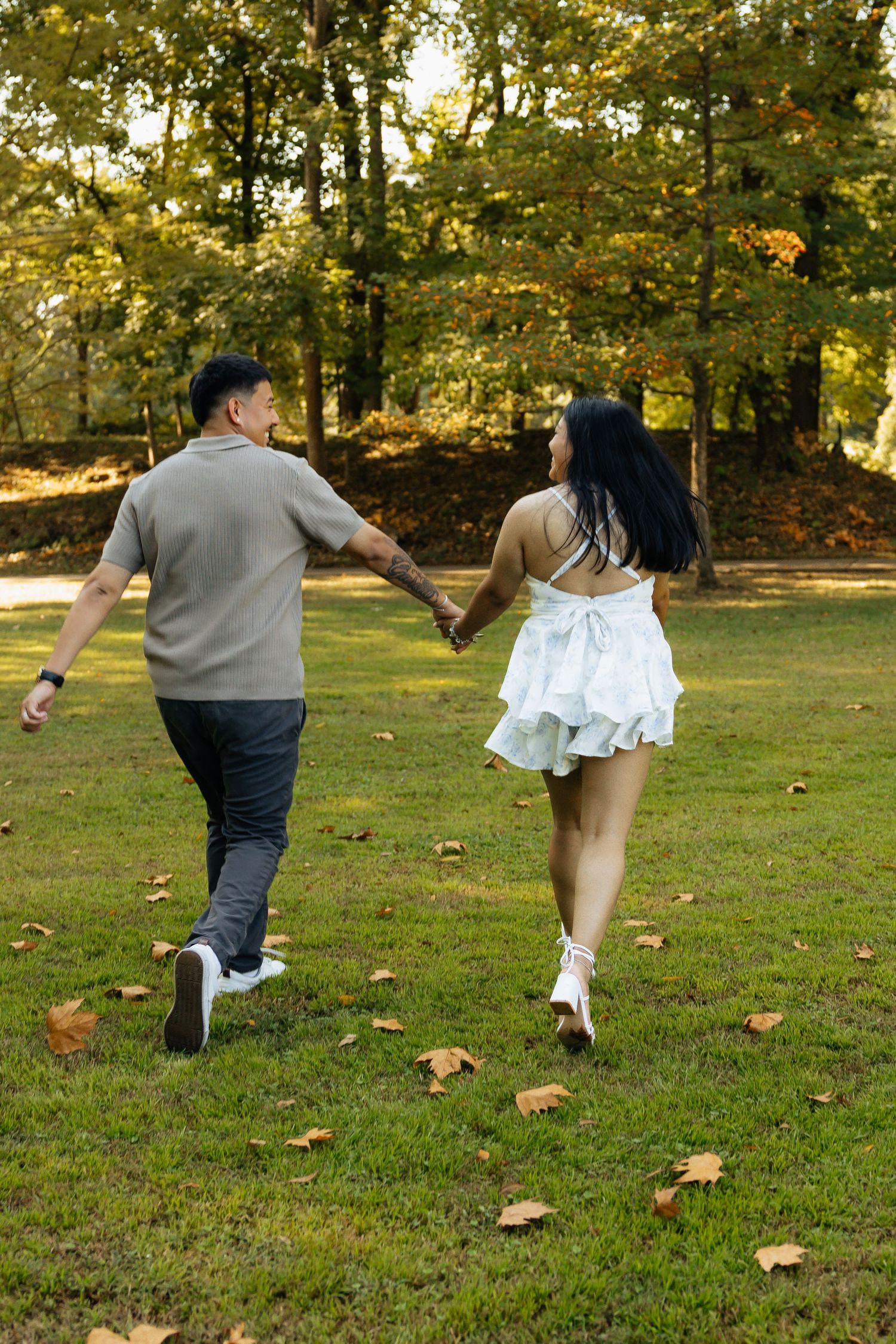 couple running. Running photos. Engagement session in the gardens. Philbrook museum of art, tulsa Oklahoma. Bride and groom. Gardens. field.