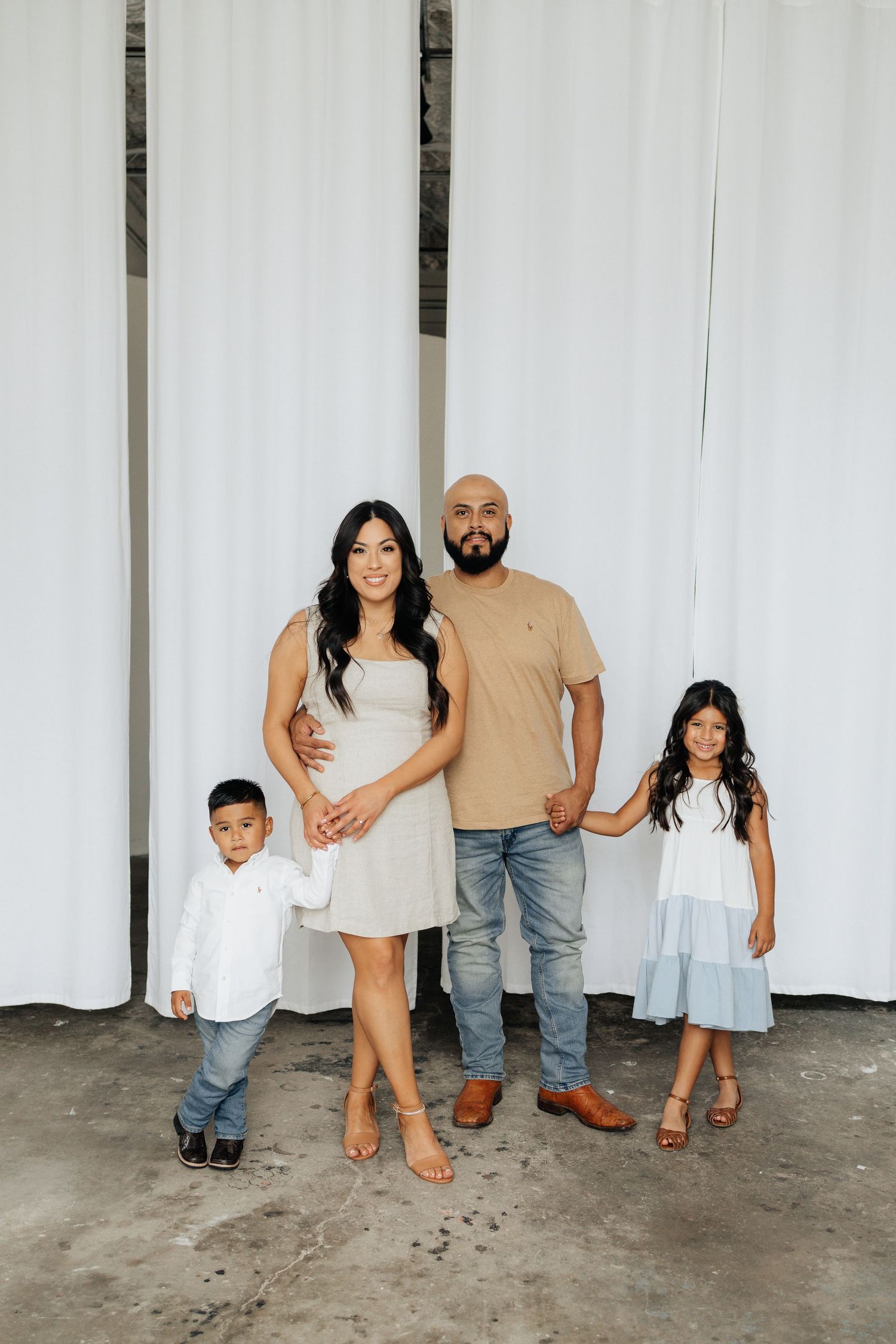 Family of four posing for a family photo during an in-studio family session.