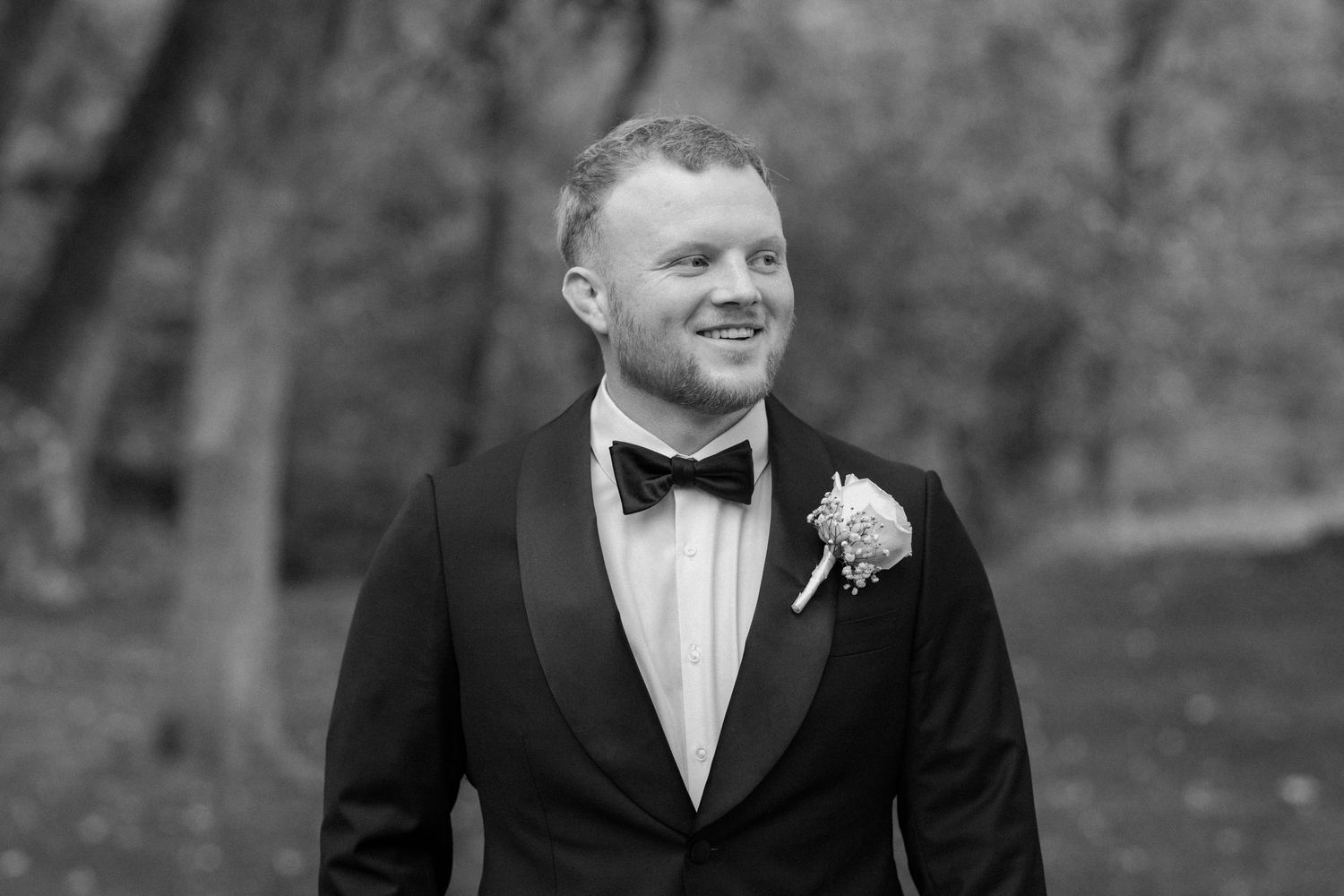 Black and white image of a groom on his wedding day.