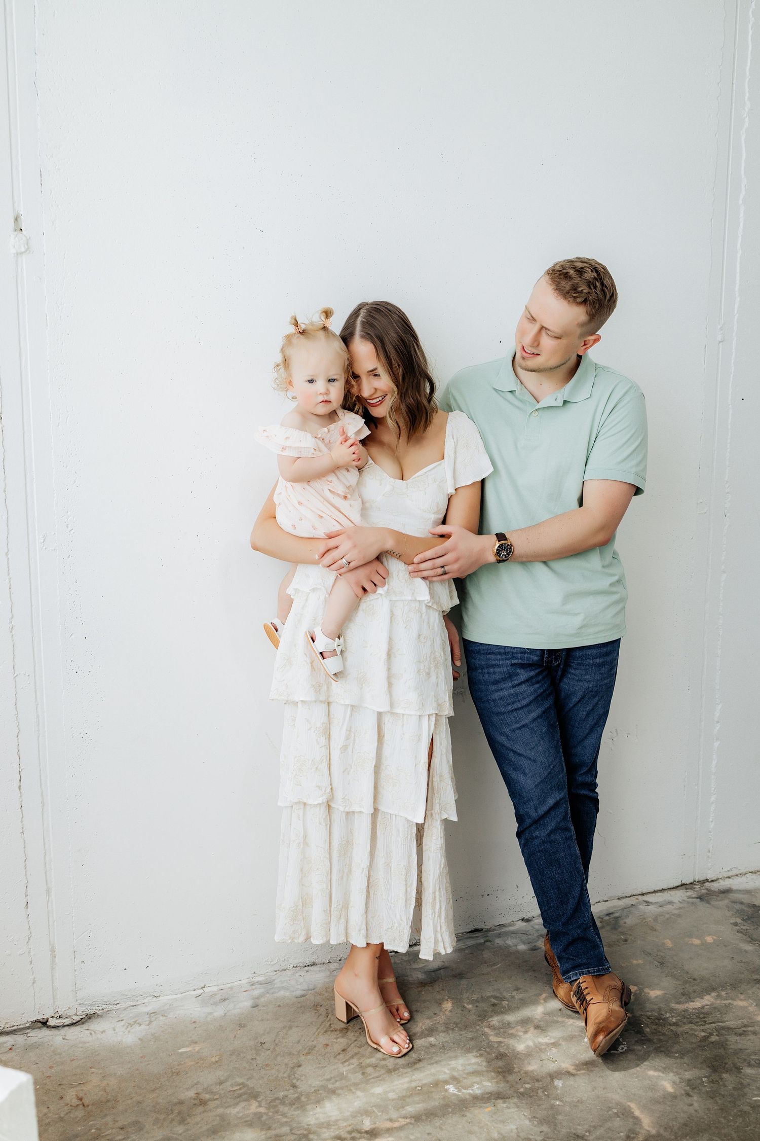 Family of three posing for a family photo during an in-studio family session.