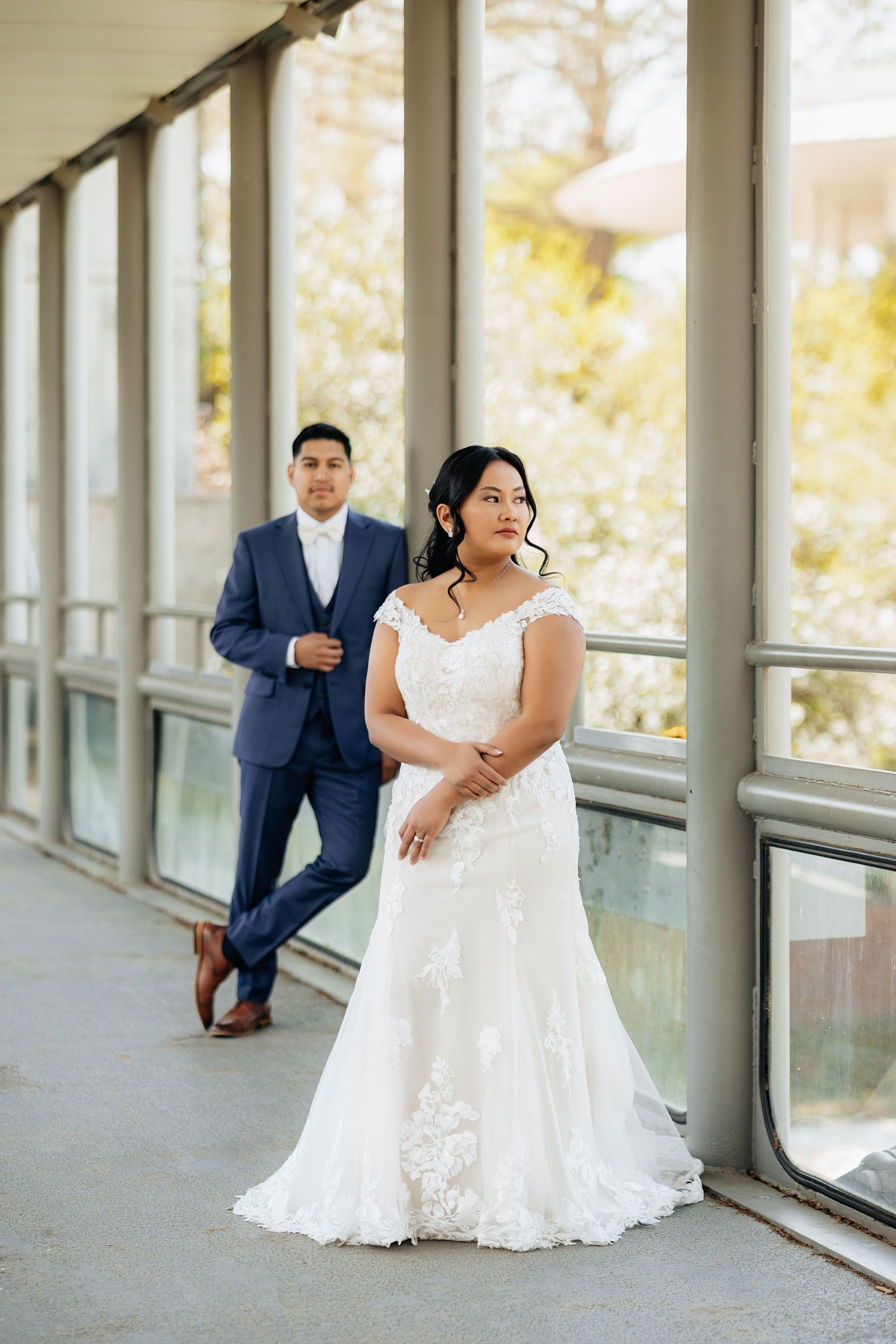 Bride and groom on their wedding day in downtown oklahoma city. Bride is dressed in a white dress. Groom is in a navy suit. Multicultural.