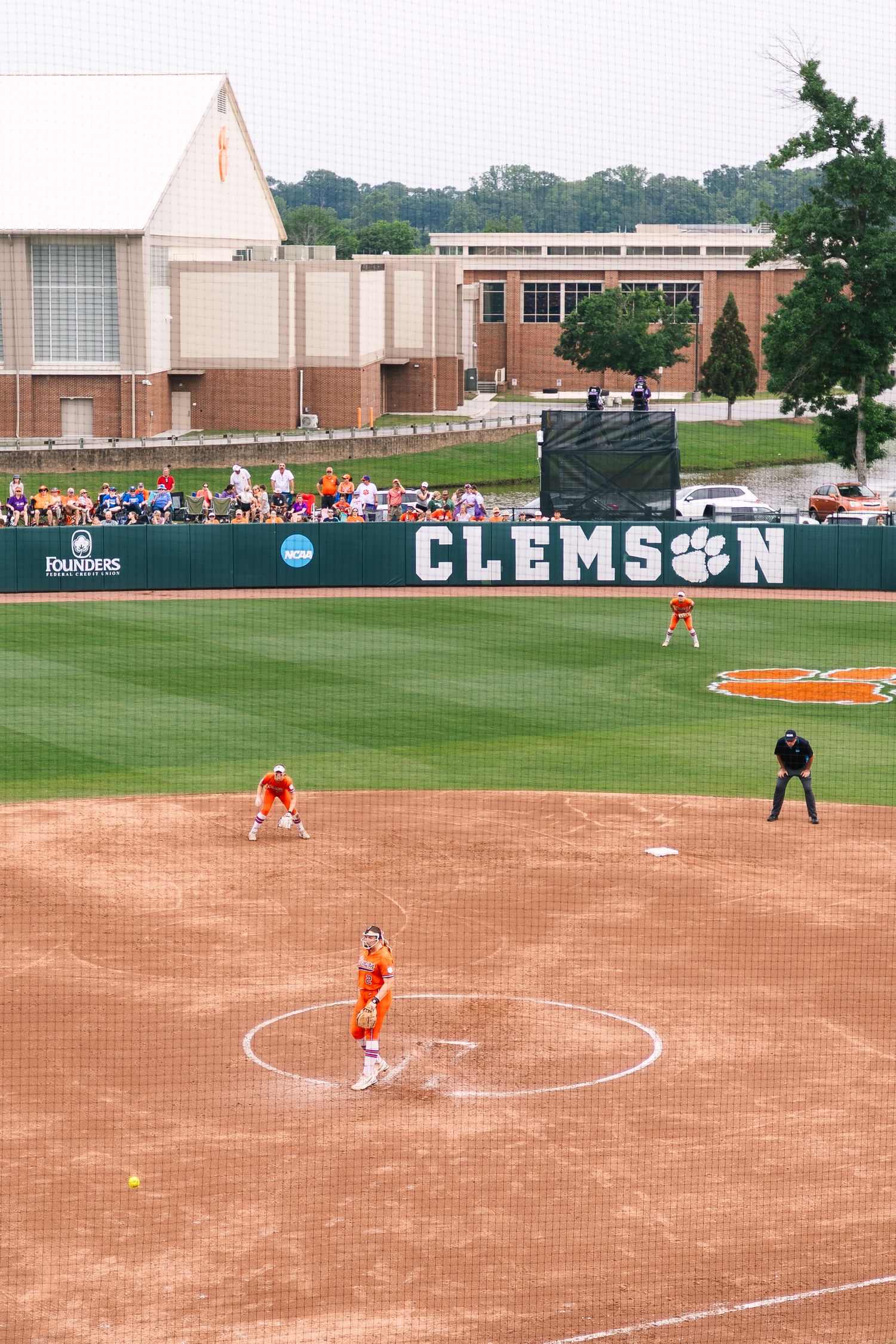 A panoramic view of a softball field at Clemson University shows players practicing on the dirt infield.