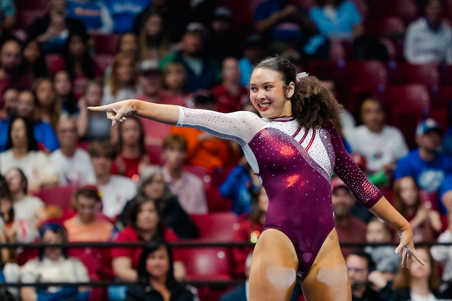 Athletes perform gymnastics routines at a competition, showcasing various athletic poses and movements on different apparatuses.