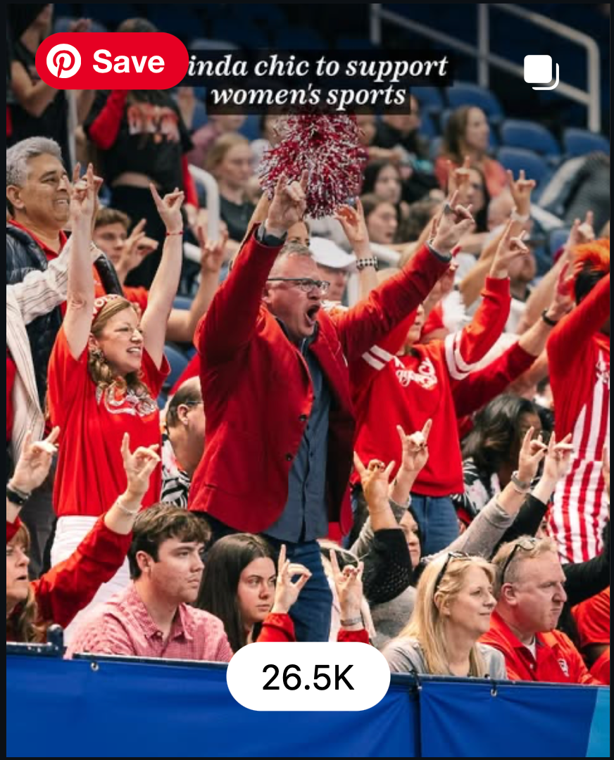 Enthusiastic fans in red cheer at a women's sports event, showing team spirit with raised hands and smiles.