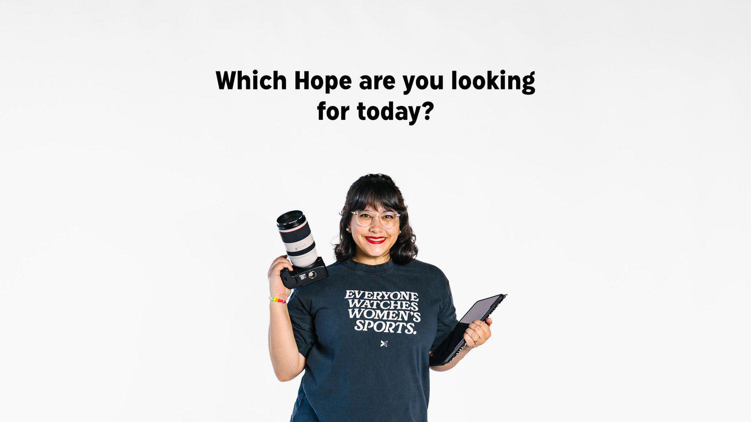 Woman in dark t-shirt holding camera lens and tablet, with text asking Which Hope are you looking for today?.