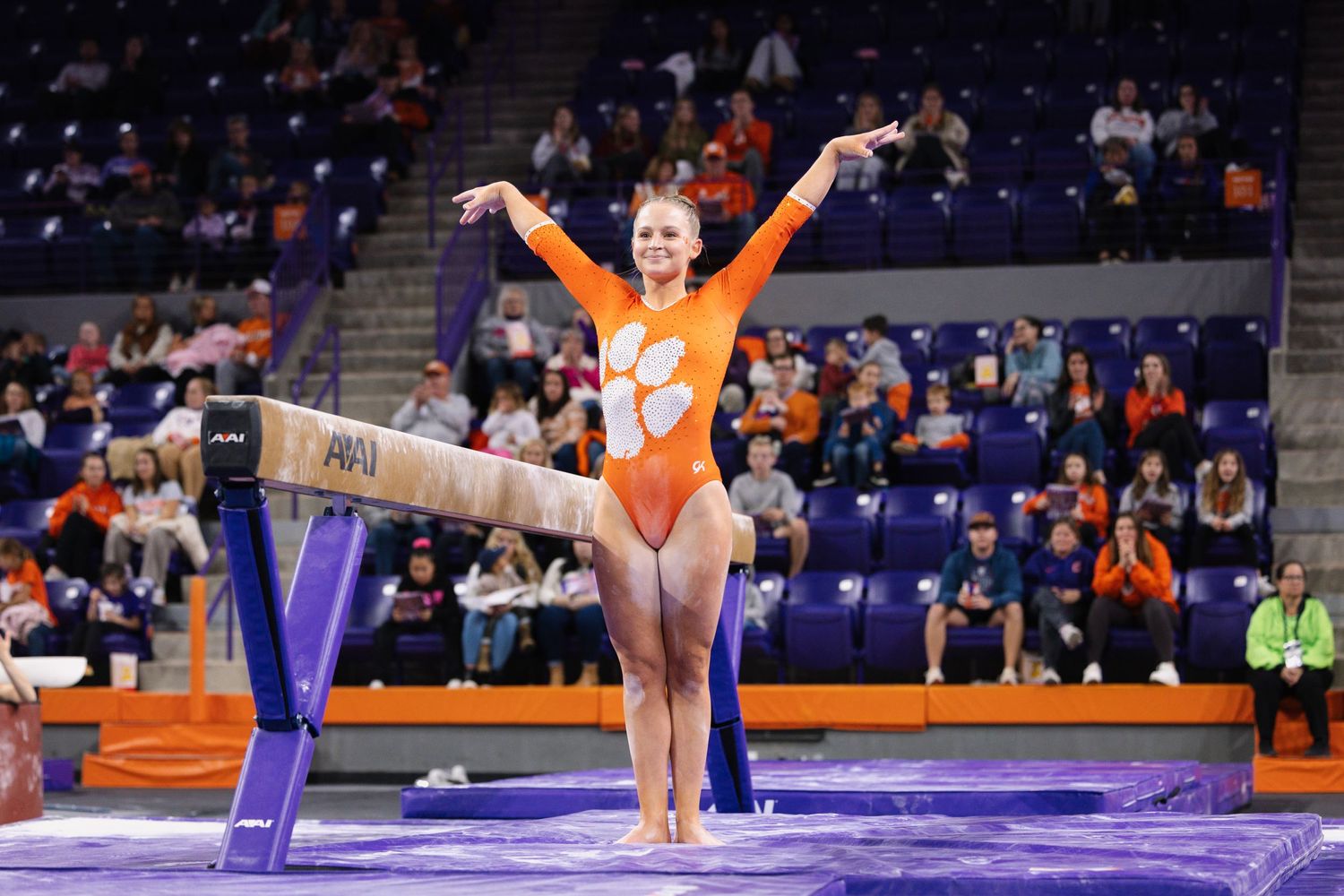 Gymnastics competition sequence showing floor exercises on purple mat with orange accents.