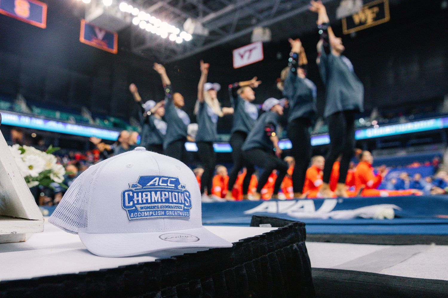 University of Pittsburgh championship hat with celebrating team in background.