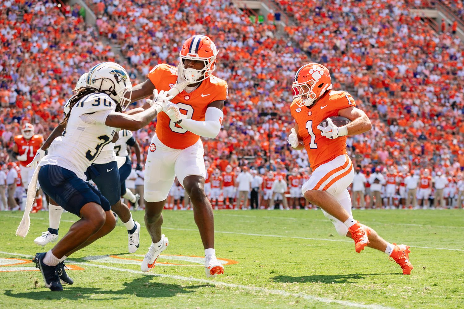 Football players from opposing teams clash during competitive game play.