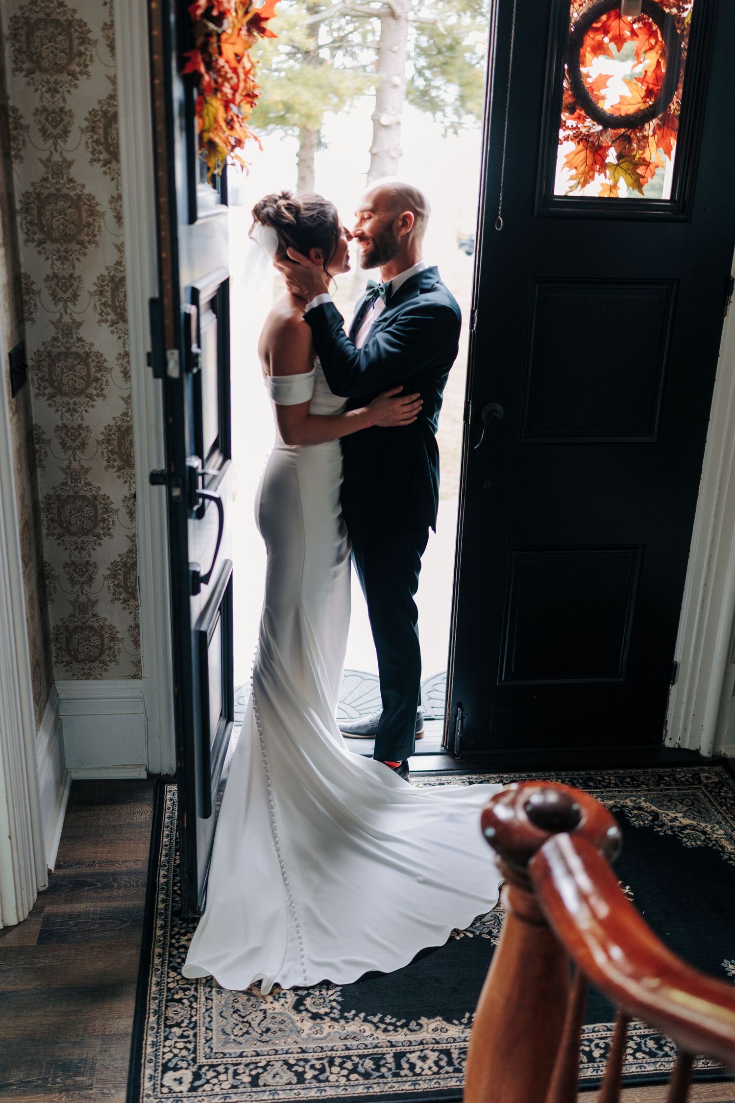 Silhouette of a couple in formal attire standing in a doorway with dramatic lighting.