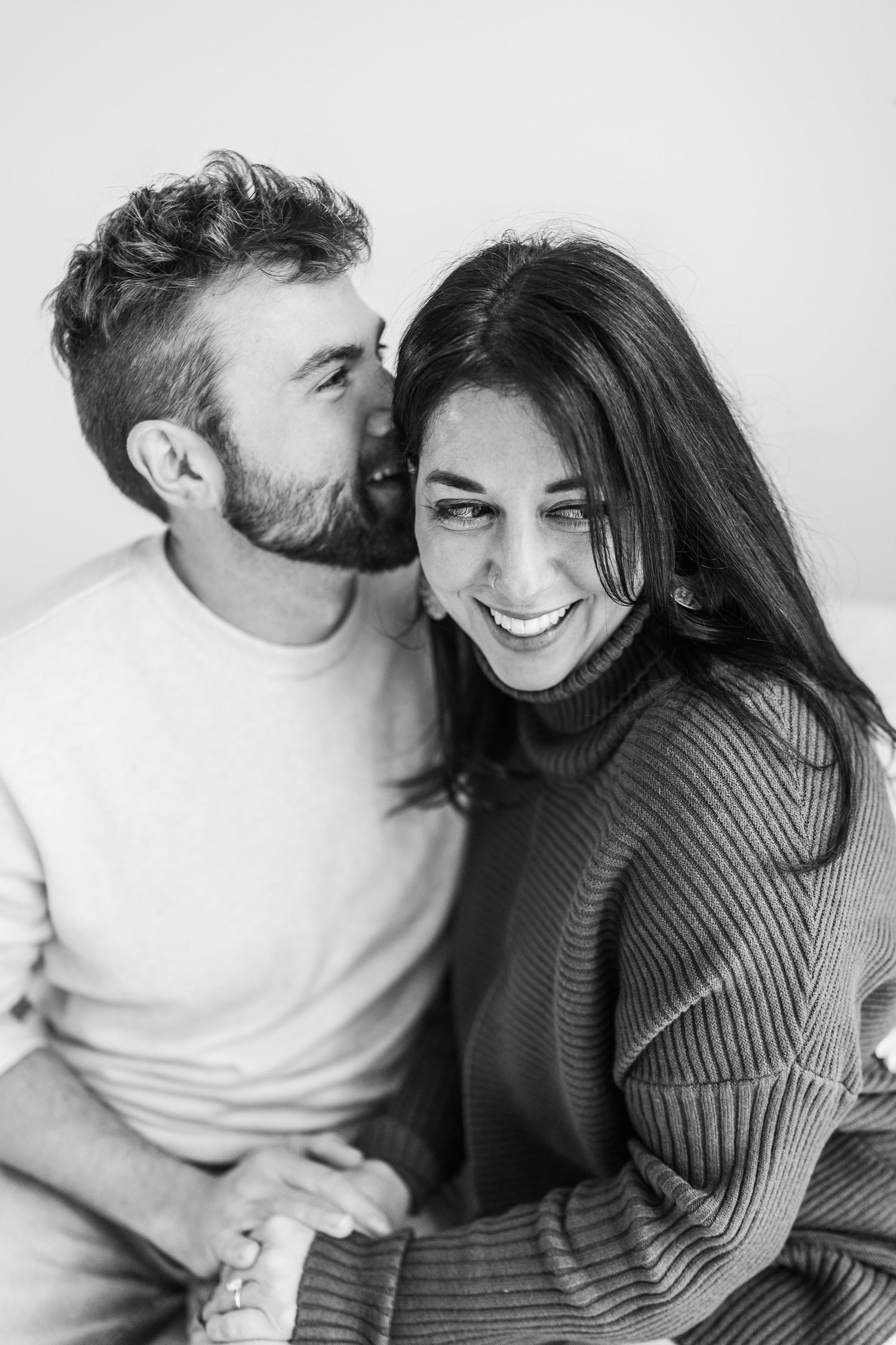 A couple shares intimate black and white moments in a series of candid photographs showing affection and laughter.