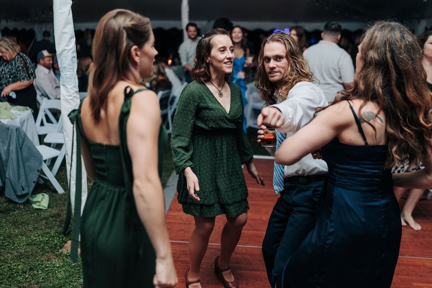 People dancing and celebrating at an evening wedding reception.